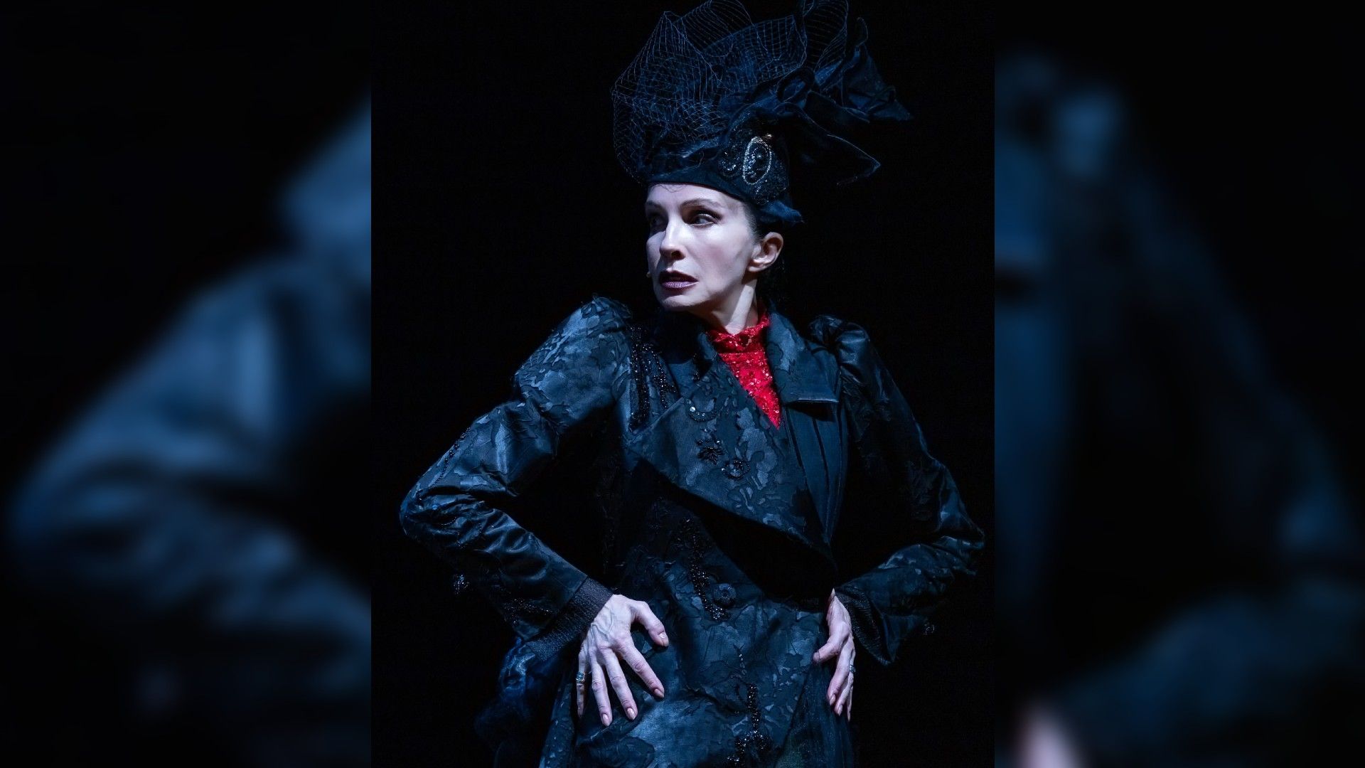 Алла Сигалова в чёрном наряде и пышной шляпе на сцене