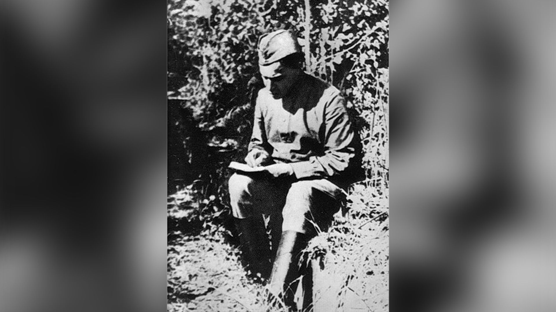 Борис Пастернак в военной форме сидит с книгой в руках