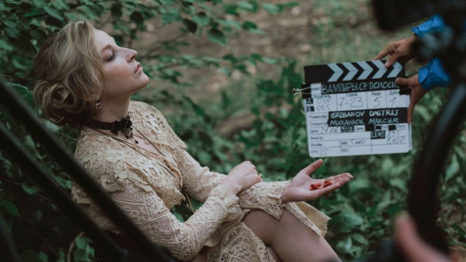 Ольга Медынич в белом кружевном платье на суку дерева, рядом хлопушка