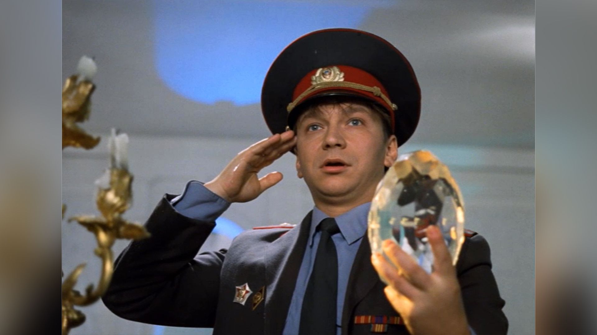 Удивлённый Игорь Угольников в форме милиционера держит в руке большой бриллиант