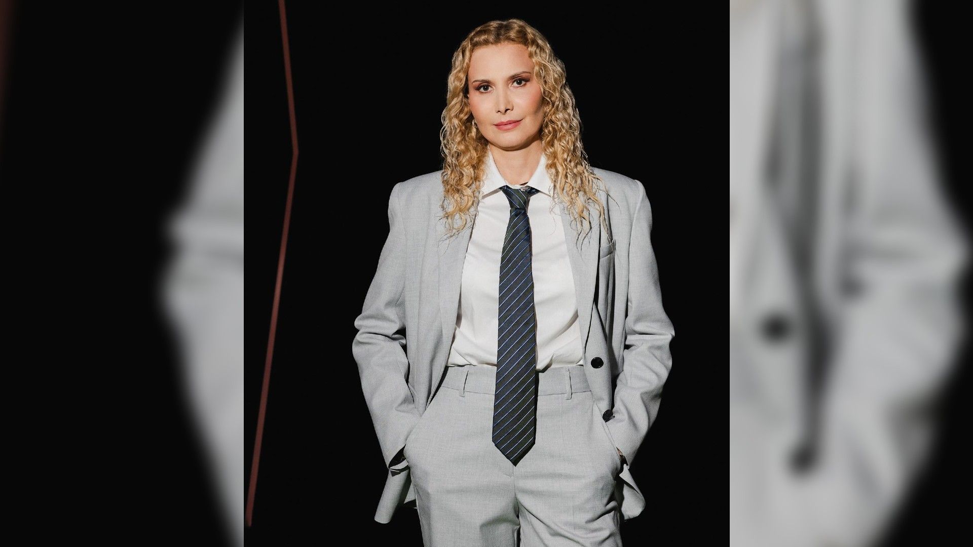 Этери Тутберидзе в строгом сером костюме позирует в полный рост