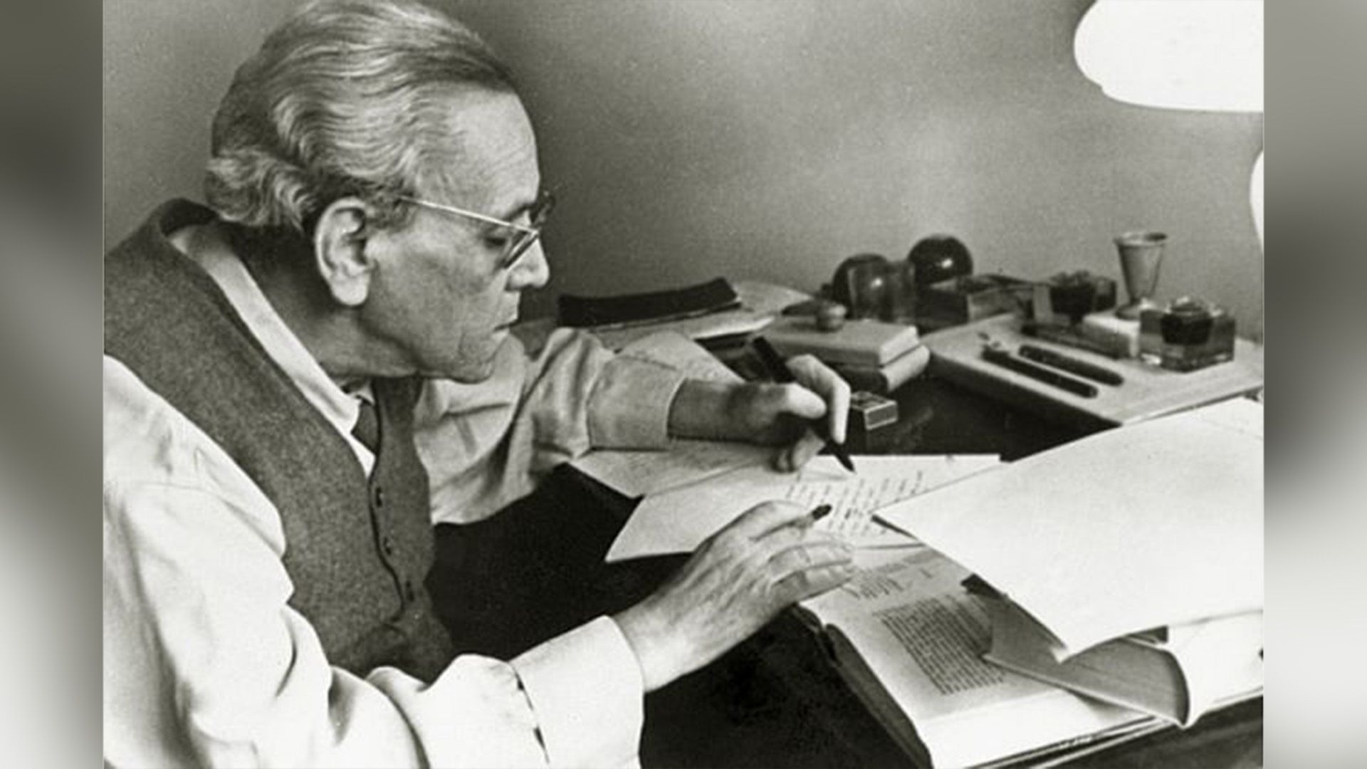 Самуил Маршак за письменным столом с открытыми книгами и тетрадями