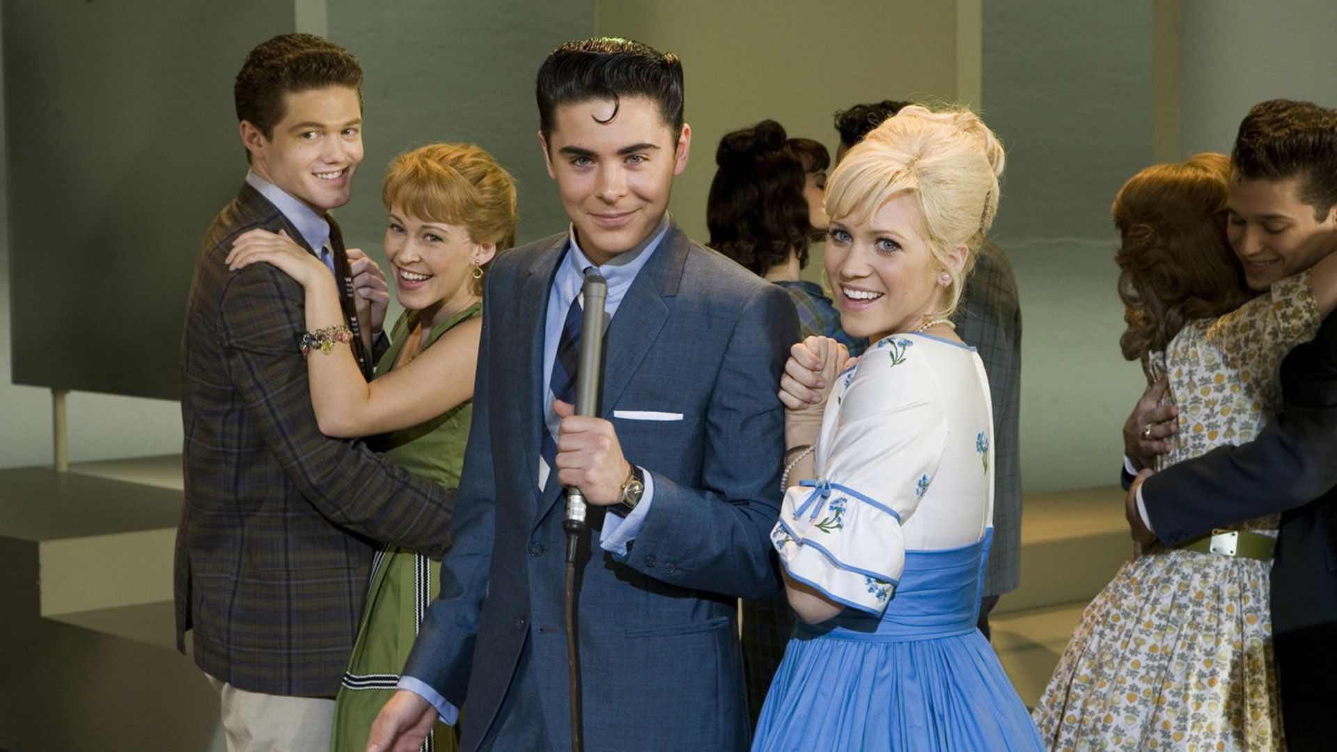 Бриттани Сноу и Зак Эфрон в нарядах в стиле 50-х, позади них танцующие пары