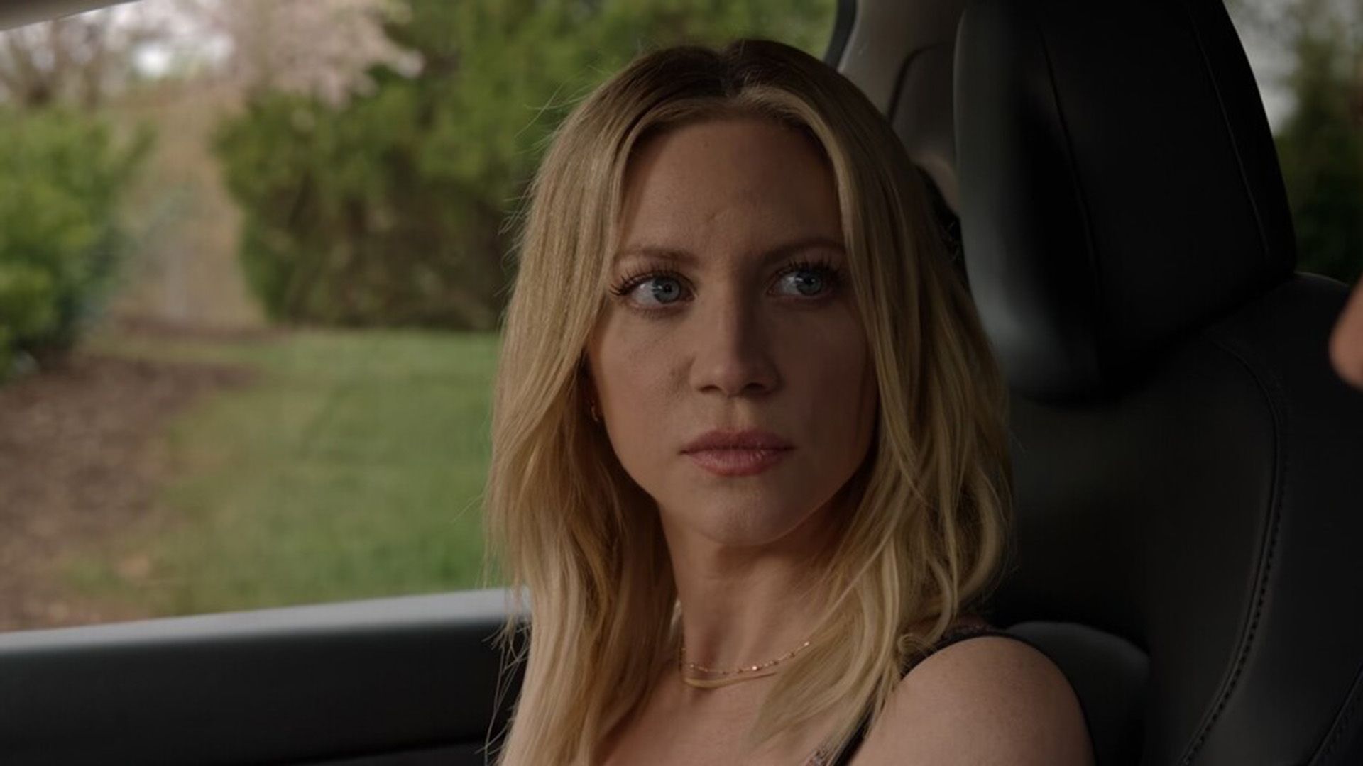 Бриттани Сноу сидит в салоне автомобиля и смотрит в сторону