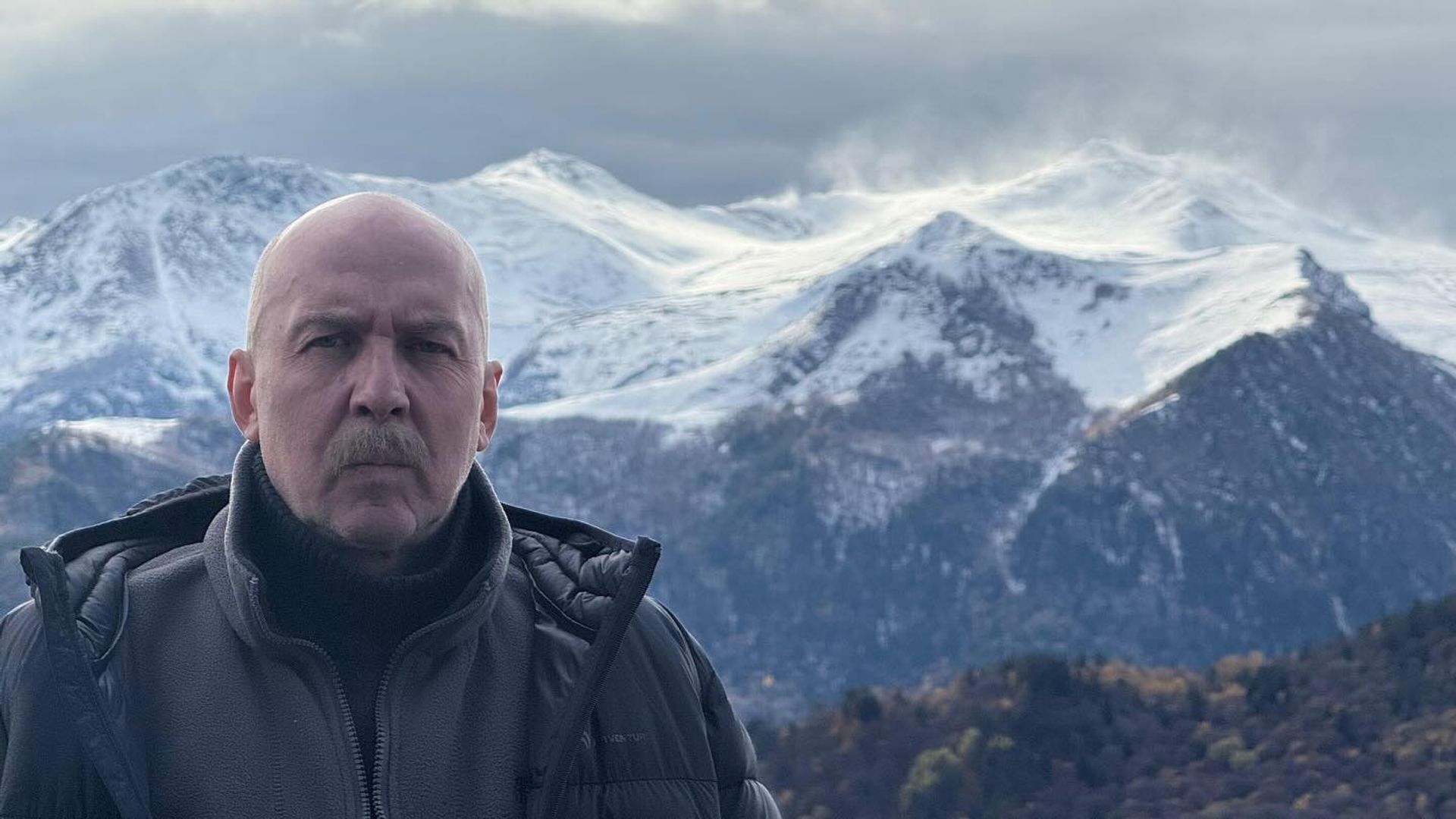 Кирилл Полухин позирует на фоне гор