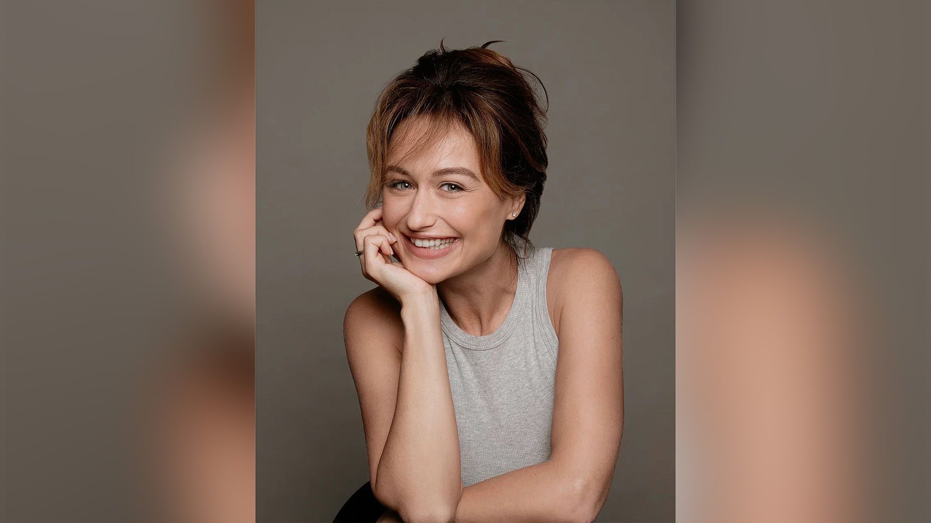 Актриса Есения Раевская в серой майке широко улыбается