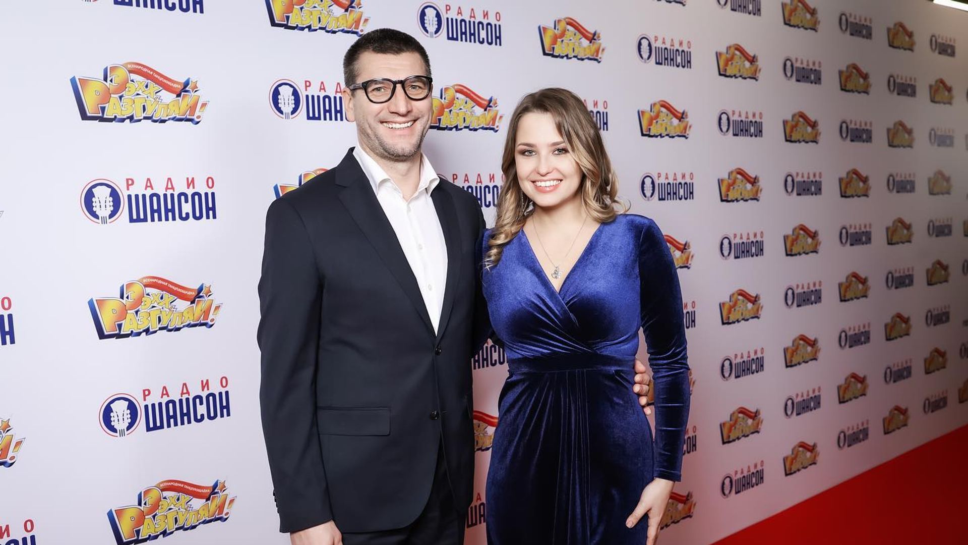 Александр Устюгов и Аглая Шиловская в вечерних костюмах позируют перед фотостеной