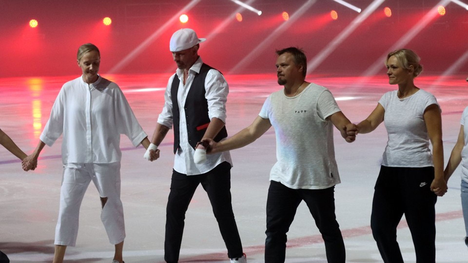 Роман Костомаров держится за руки с фигуристами на катке