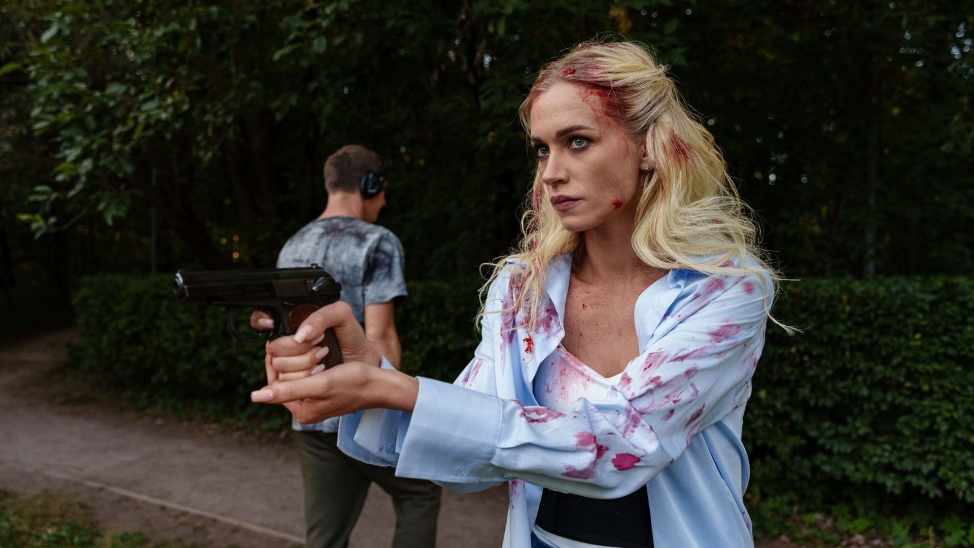 Валерия Астапова в имитирующем кровь гриме держит в руках пистолет