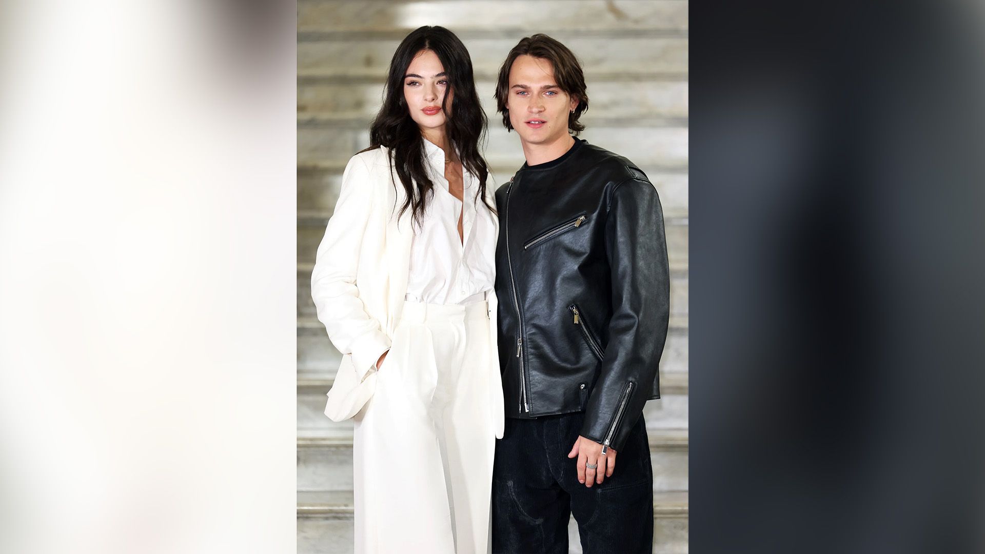 Дева Кассель в белом брючном костюме и Сол Нанни в чёрной кожаной куртке