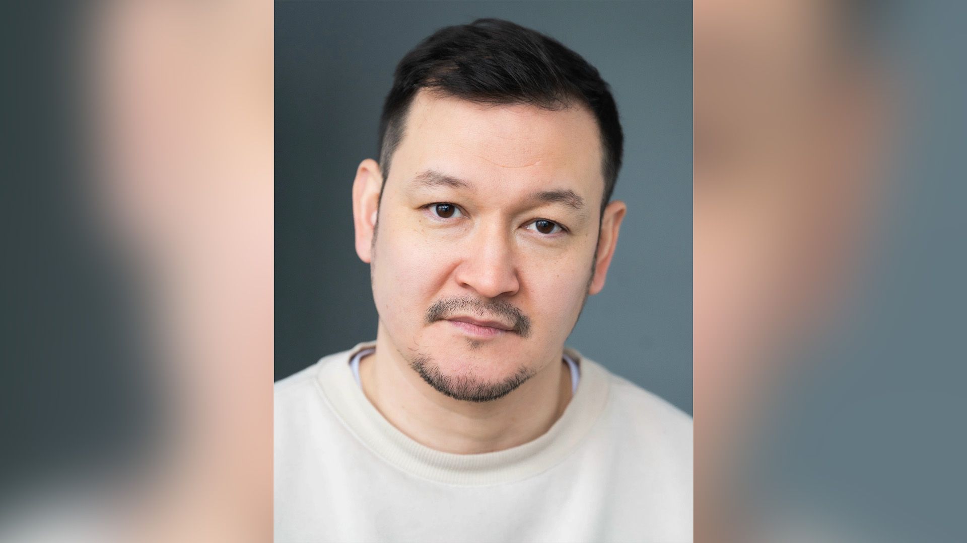 Актёр Ренат Мухамбаев в белой футболке крупным планом