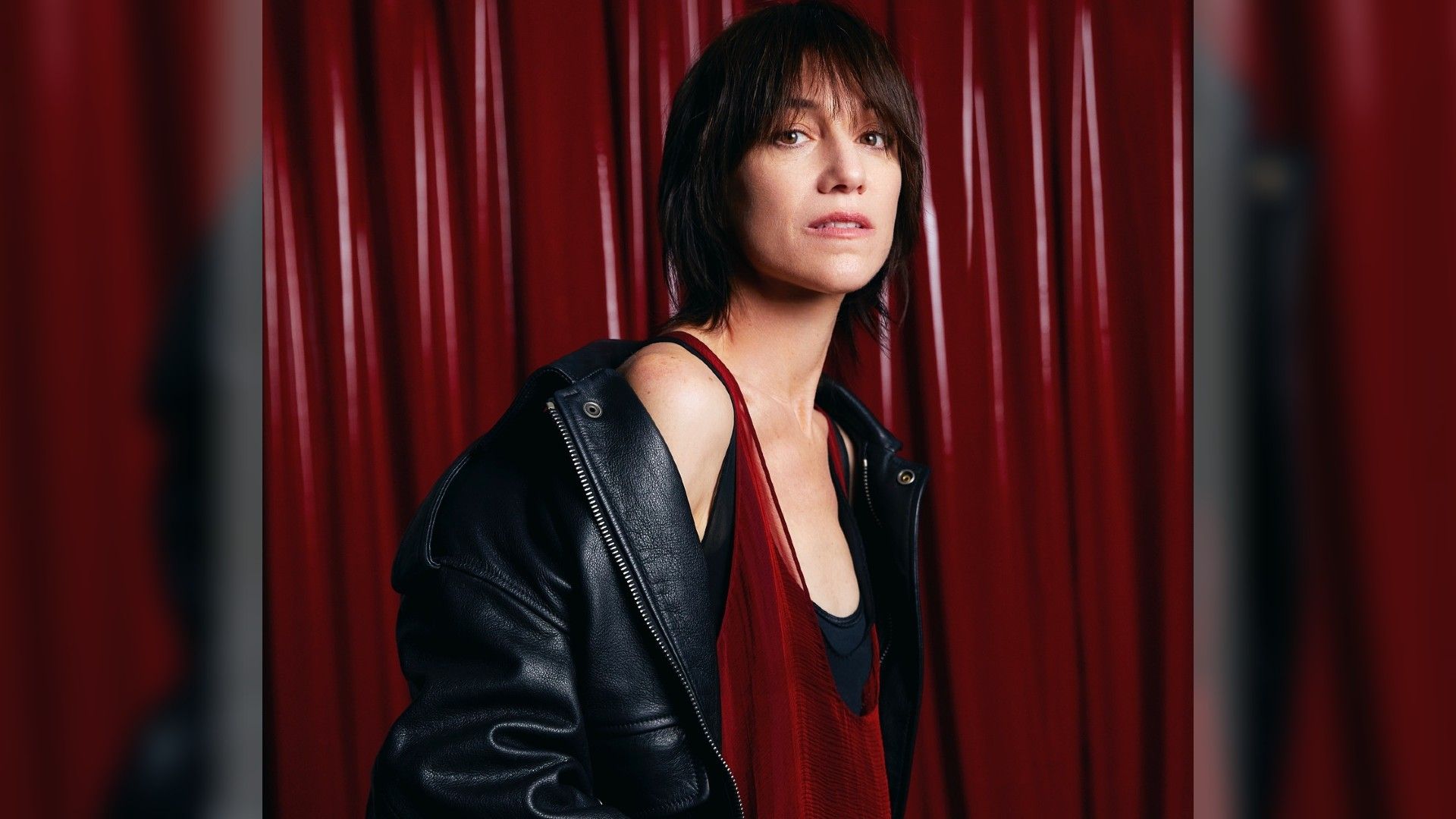 Шарлотта Генсбур в красном платье позирует на красном фоне