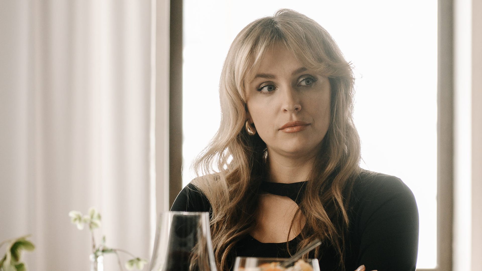 Елена Дудина в чёрном платье смотрит вбок, сложив руки