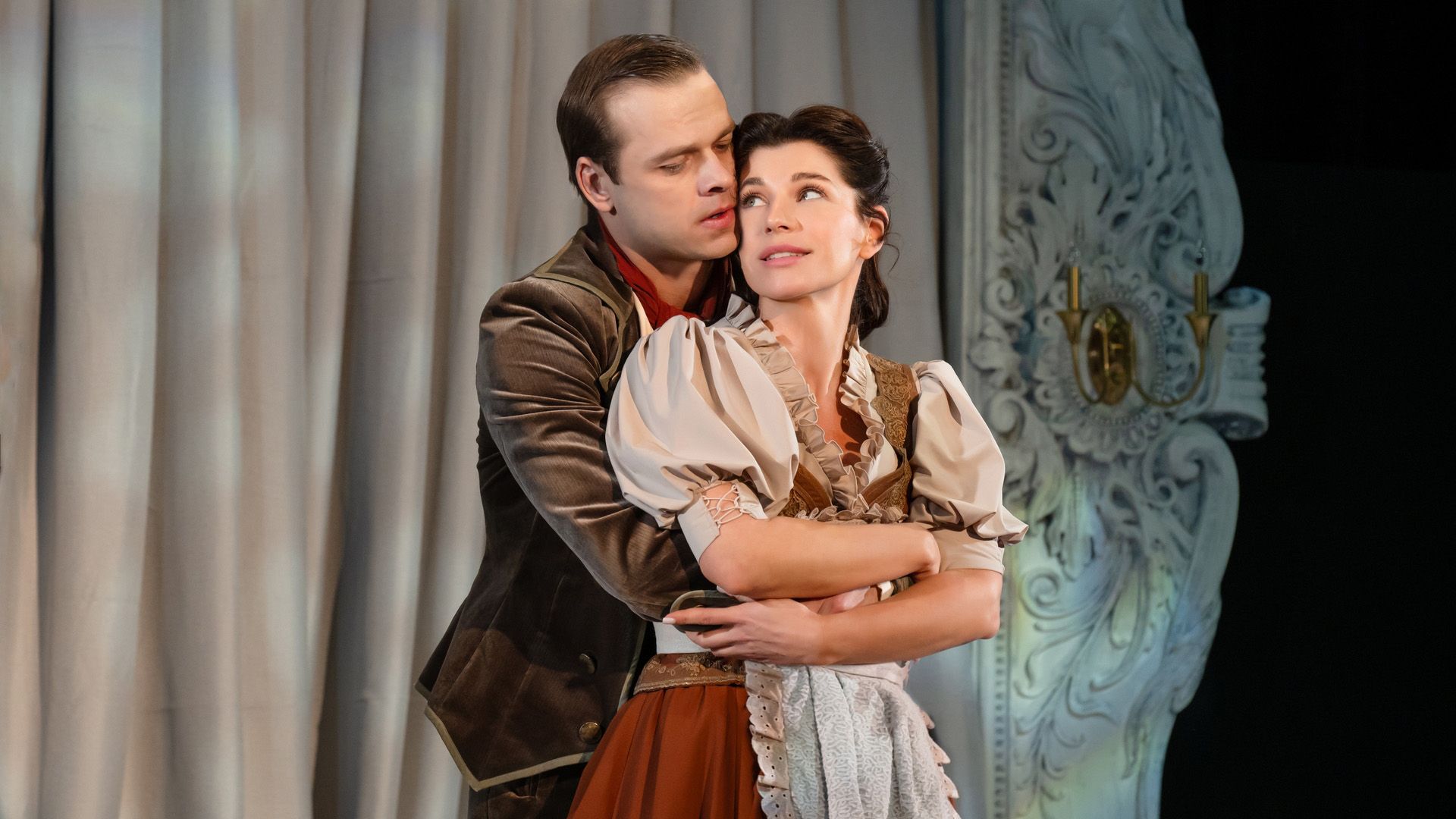 Влад Канопка в коричневой бархатной куртке обнимает со спины Екатерину Волкову