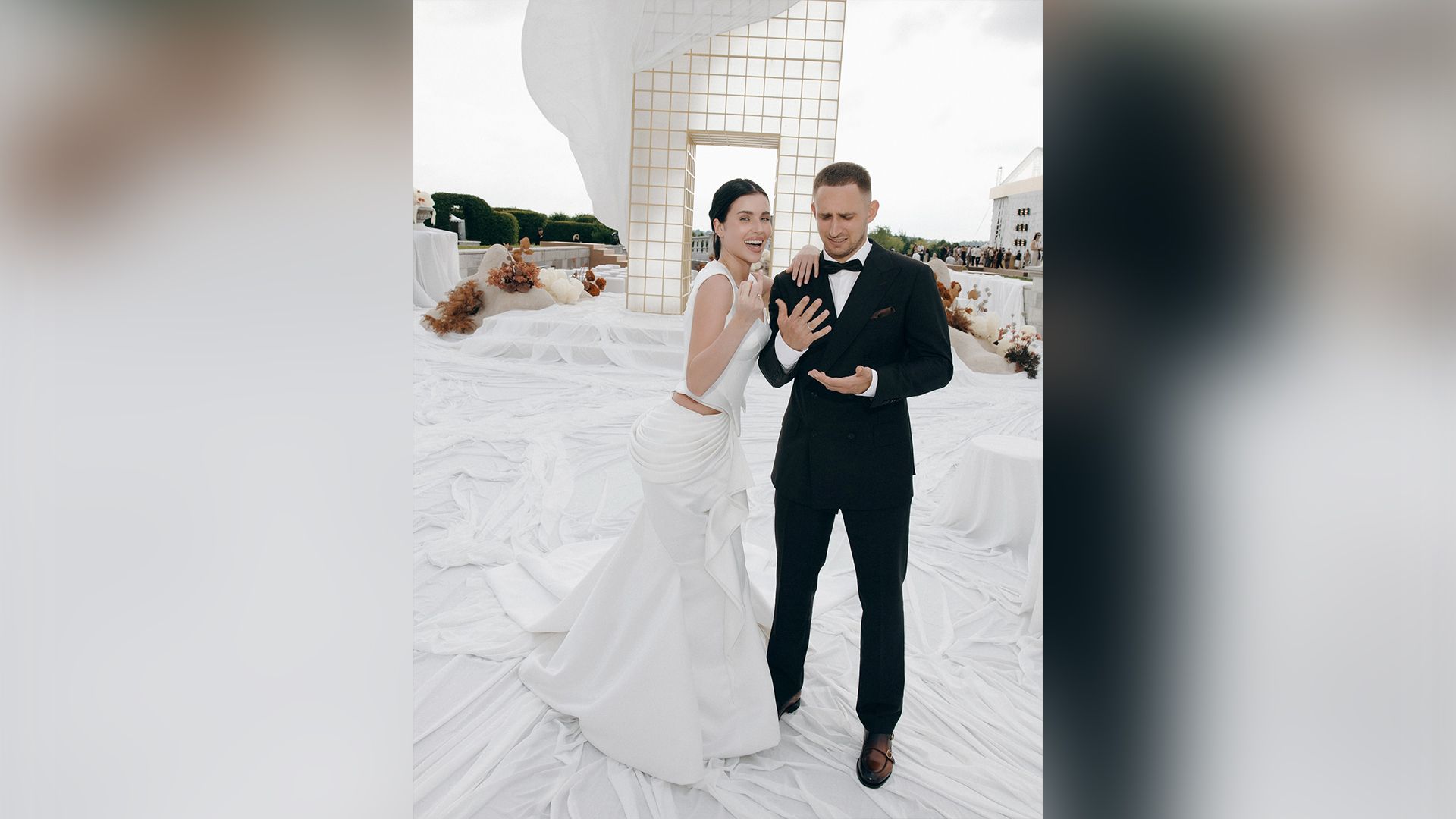 Адель Вейгель в свадебном платье и Михаил Литвин в смокинге показывают кольца на безымянных пальцах