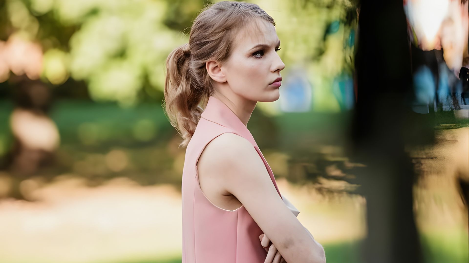 Мария Фомина в розовом платье стоит, вид сбоку