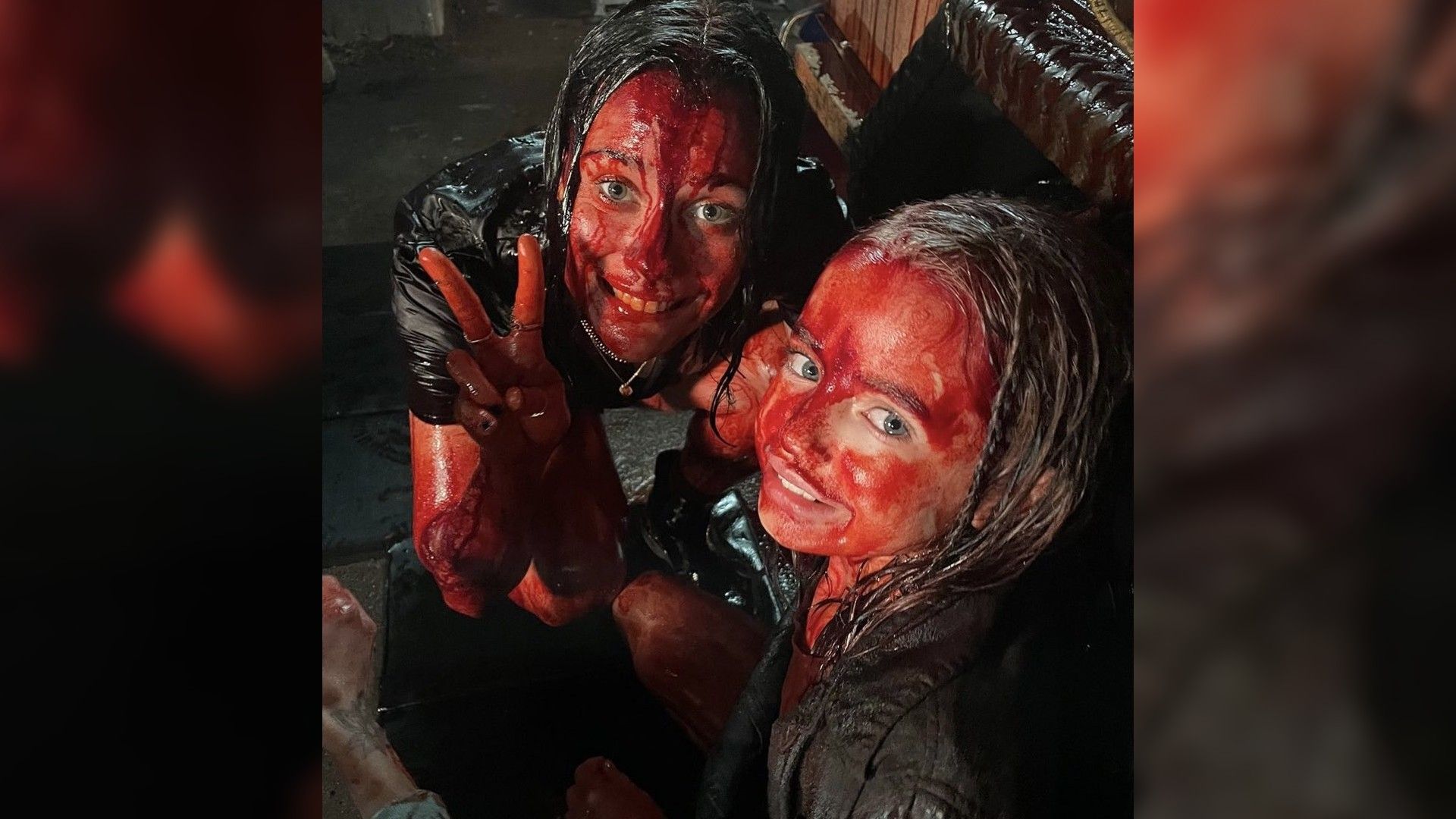 Нелл Фишер и Лили Салливан в красном гриме, имитирующем кровь, улыбаются на камеру