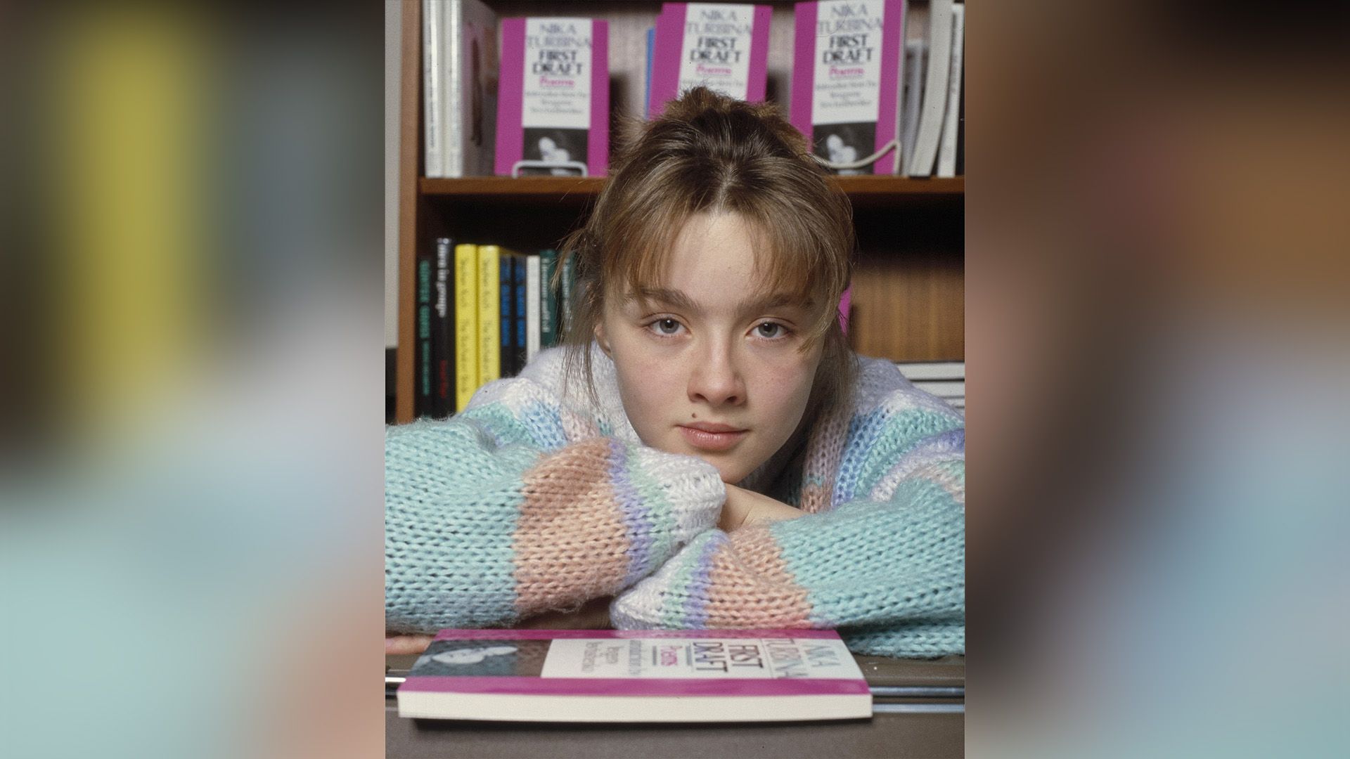 Поэтесса Ника Турбина в вязаном свитере облокотилась на стол