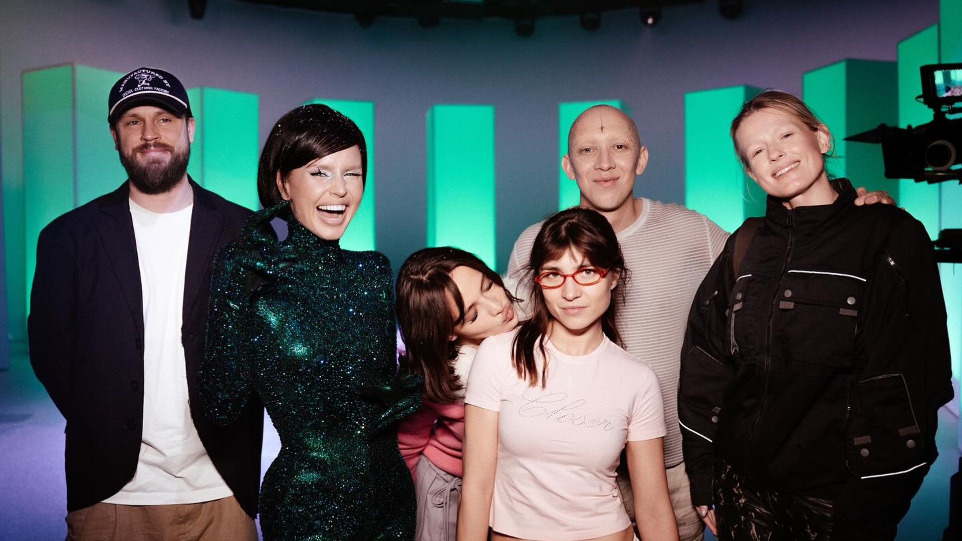 Группа актёров в ярких нарядах делает групповое фото