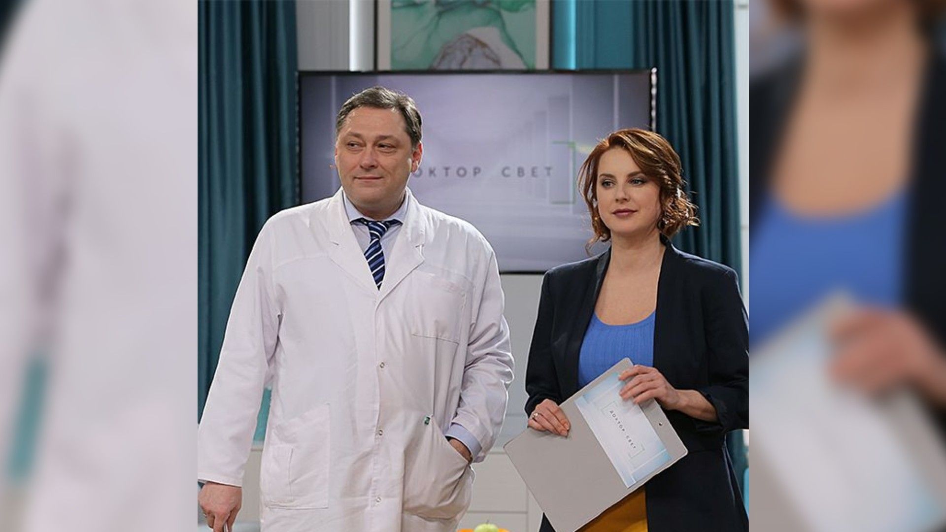 Ирина Слуцкая в пиджаке и Алексей Свет в белом халате стоят на фоне доски с надписью Доктор Свет