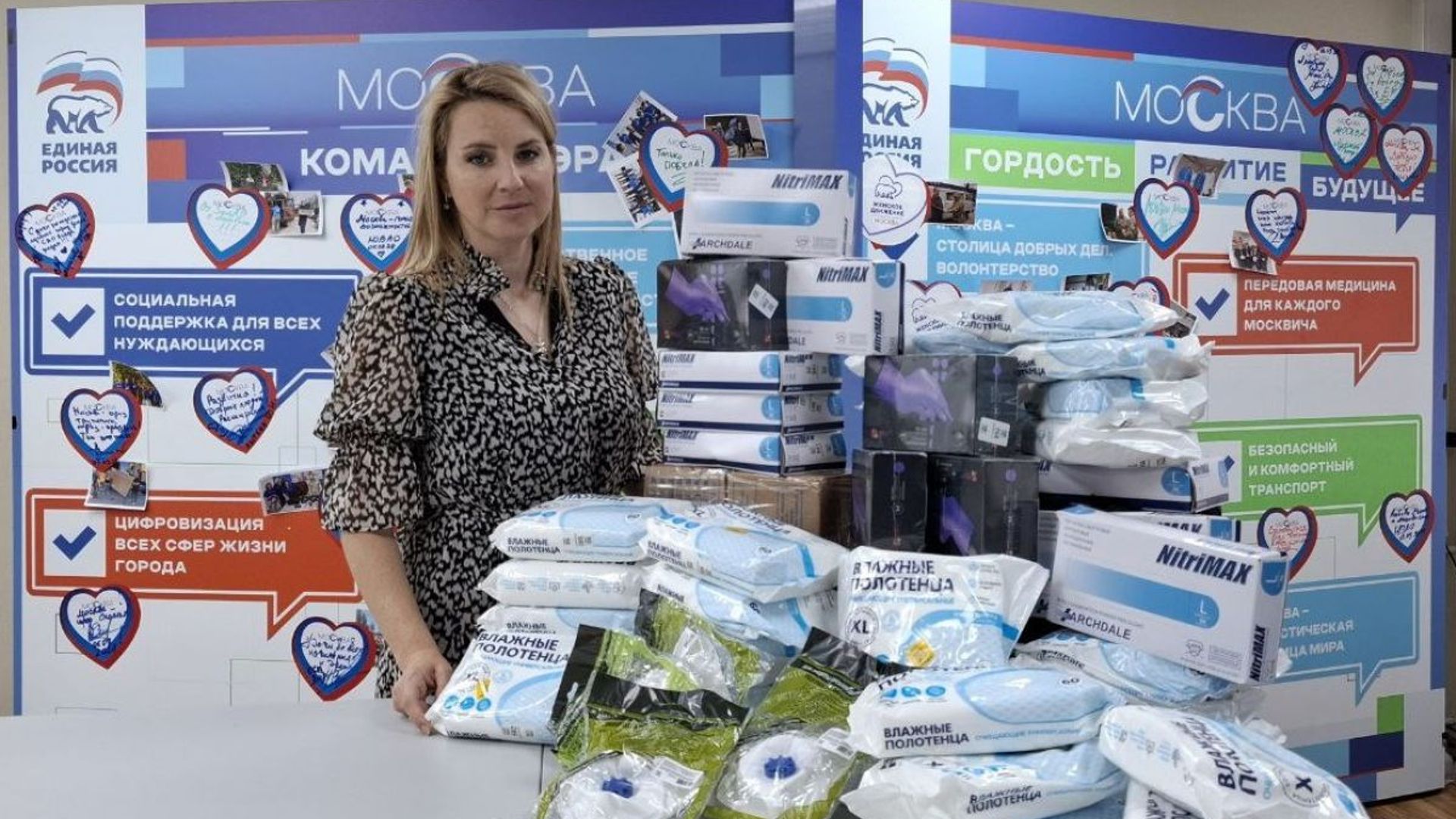 Ирина Слуцкая стоит у стола со множеством упаковок влажных салфеток