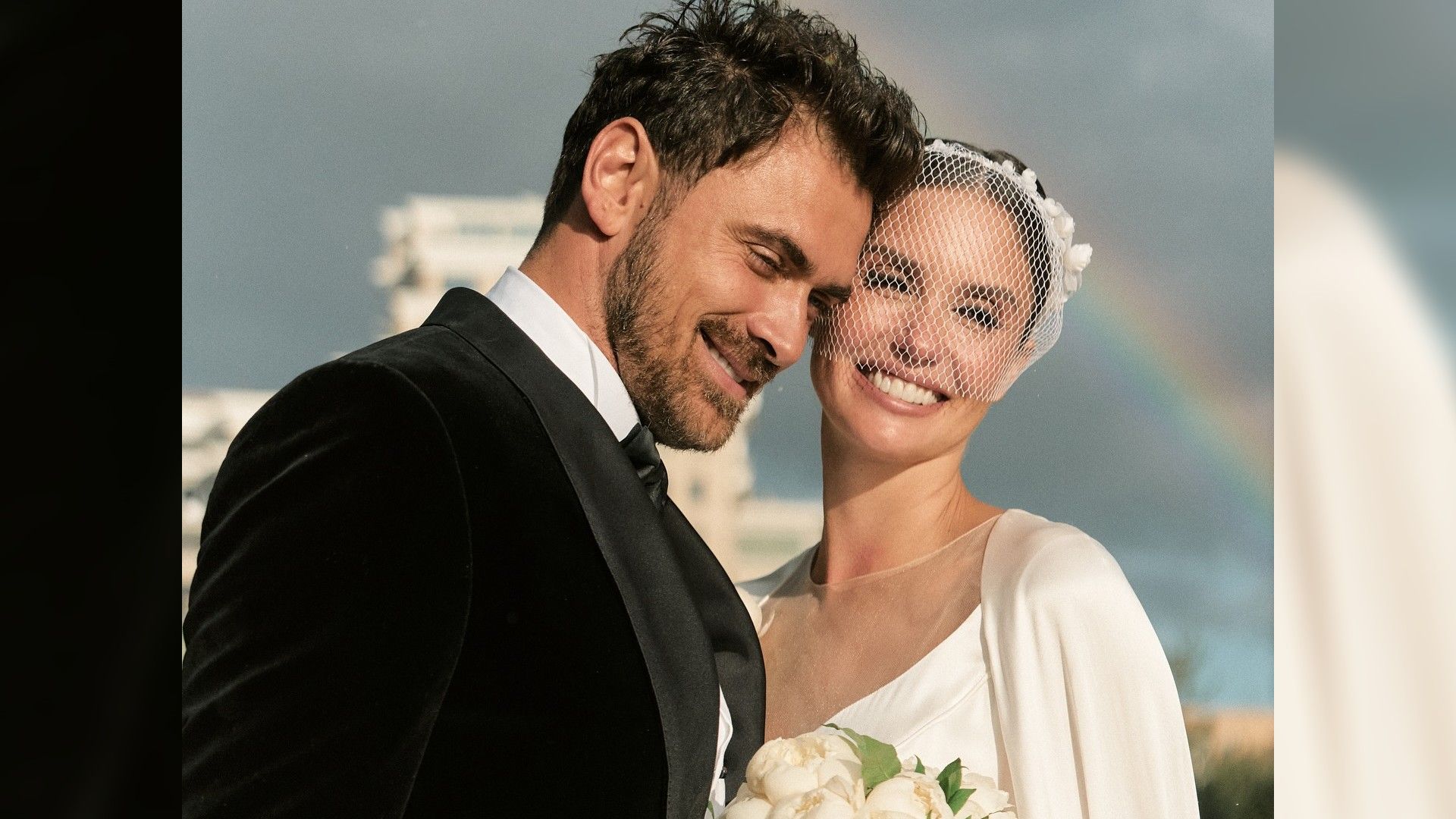 Агата Муцениеце и Пётр Дранга в свадебных нарядах, на фоне радуга