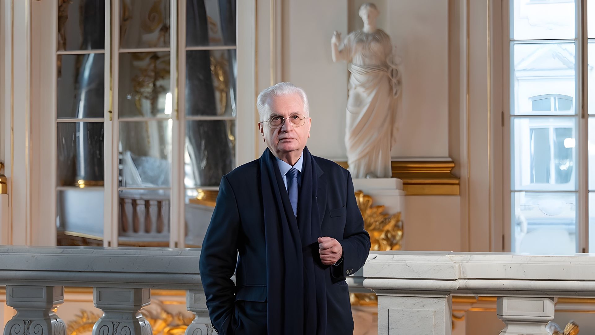 Михаил Пиотровский на фоне лестницы Эрмитажа