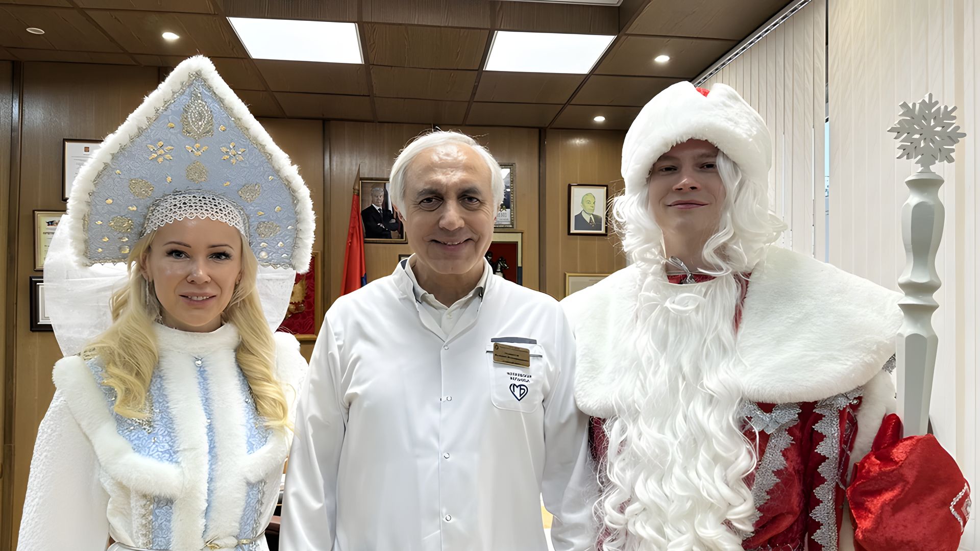 Певец Ярослав Дронов в костюме Деда Мороза и Екатерина Мизулина в костюме Снегурочки фотографируются с врачом