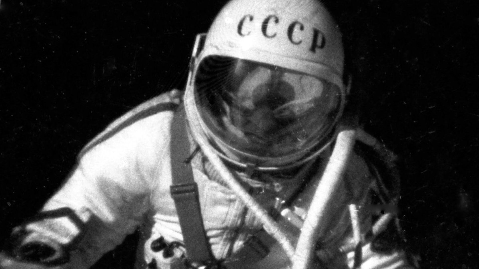 Космонавт в скафандре на чёрном фоне