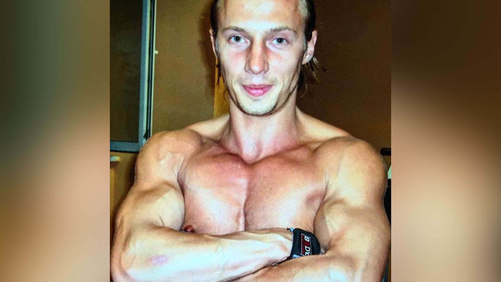 Мускулистый молодой мужчина скрестил руки на груди