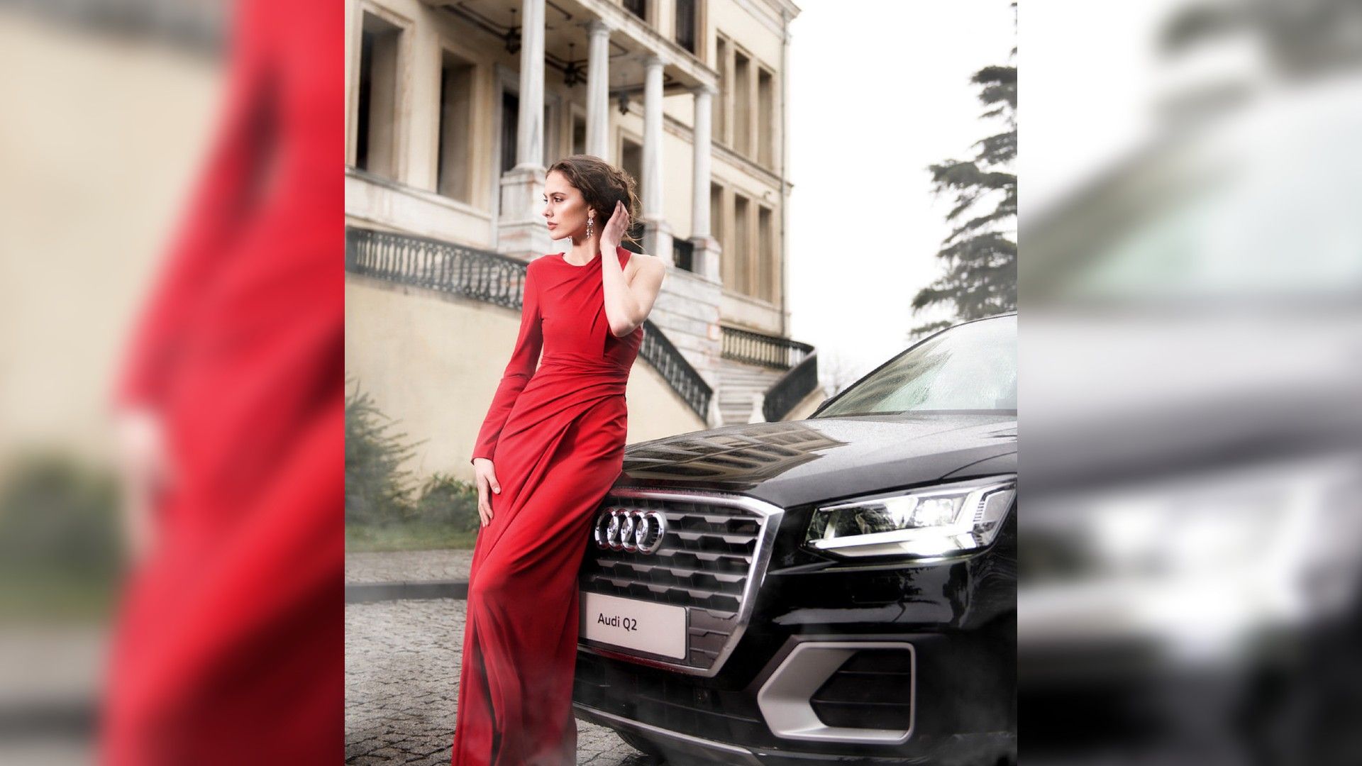 Девушка в вечернем красном платье позирует на фоне автомобиля Audi Q2