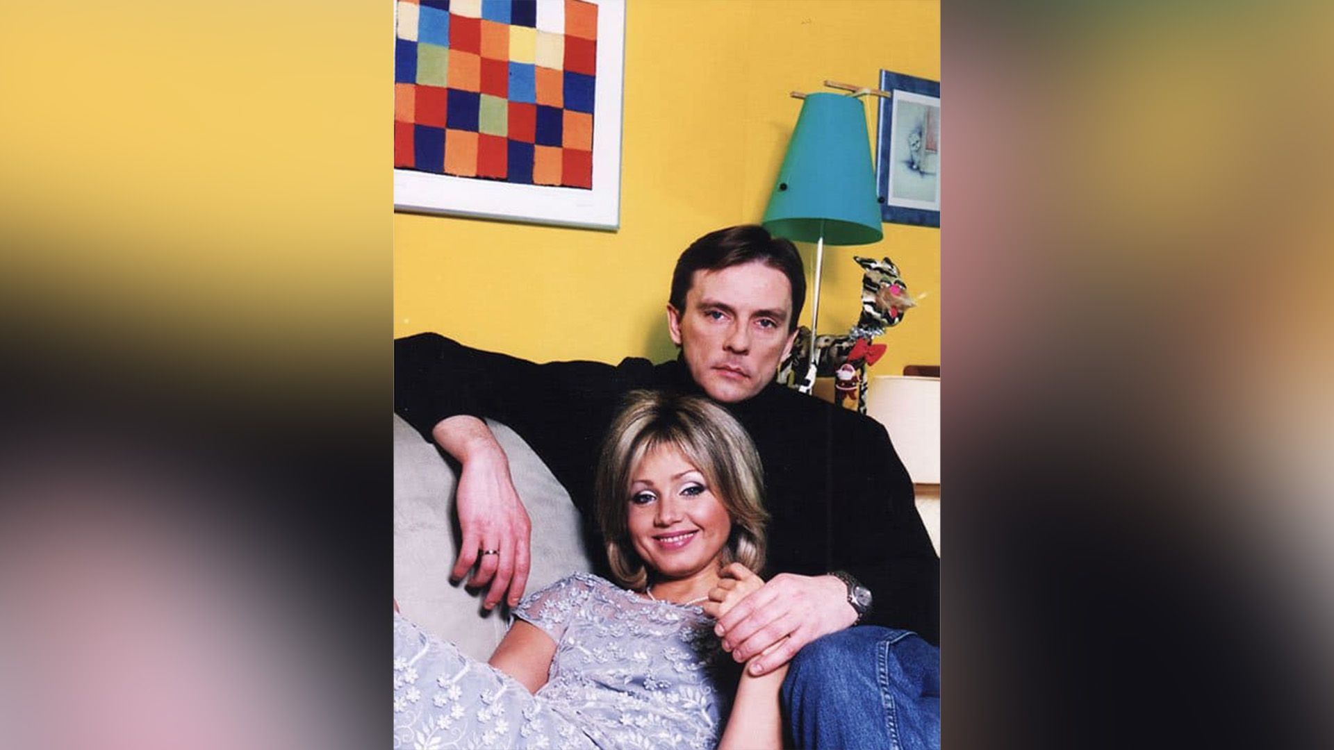 Актёры Ирина Климова и Алексей Нилов на диване на фоне жёлтой тены