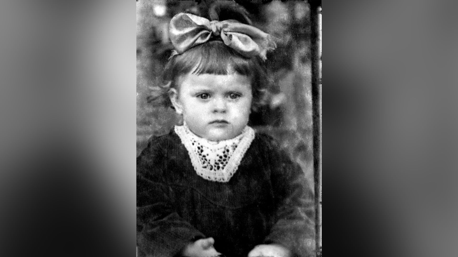Татьяна Никитина в возрасте одного года с большим бантом на голове