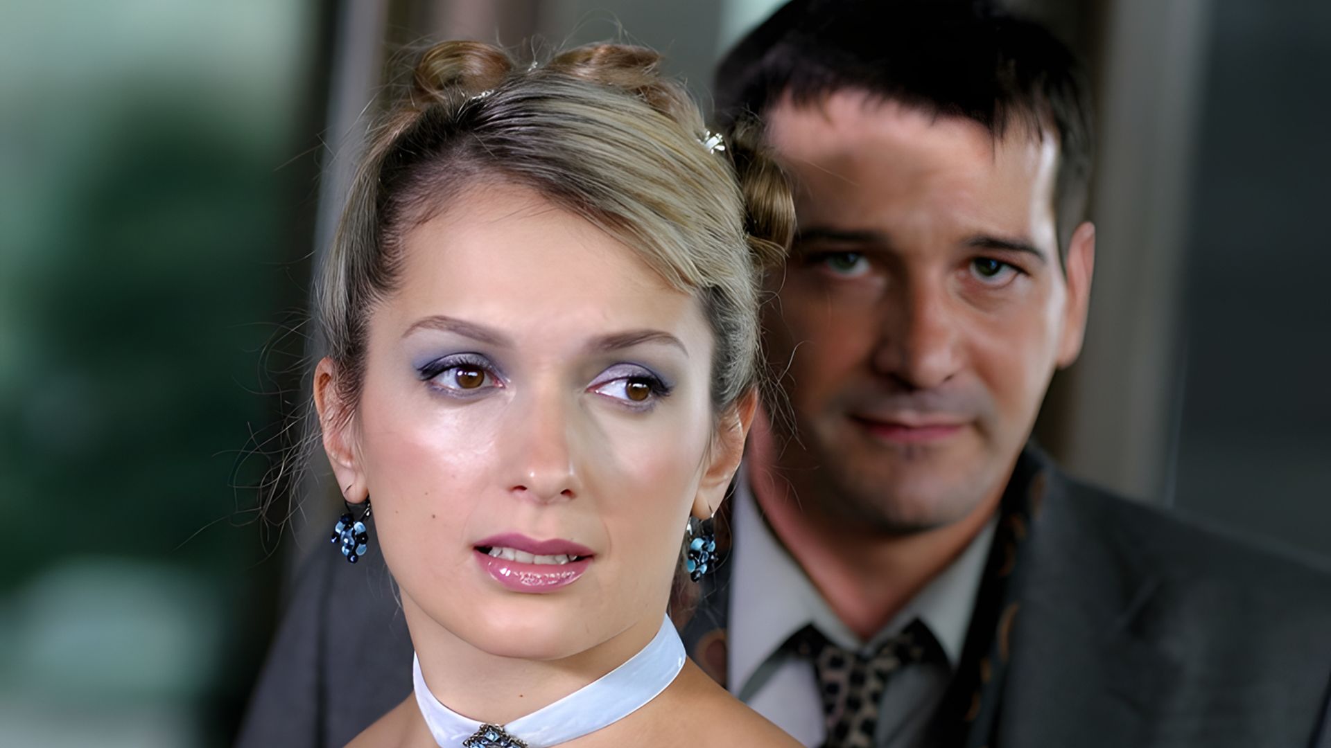 Мария Порошина с белым чокером и серьгами смотрит в сторону, Ярослав Бойко в костюме стоит позади, слегка улыбаясь