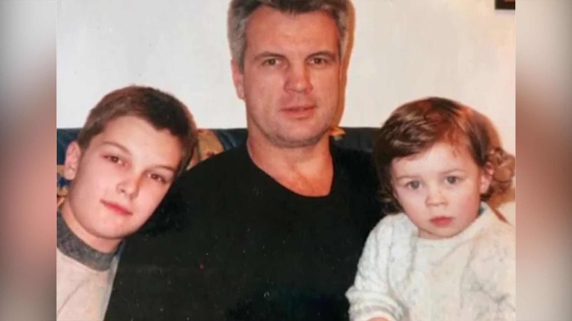 Анатолий Котенёв сидит на диване с маленькими сыновьями Владимиром и Климом