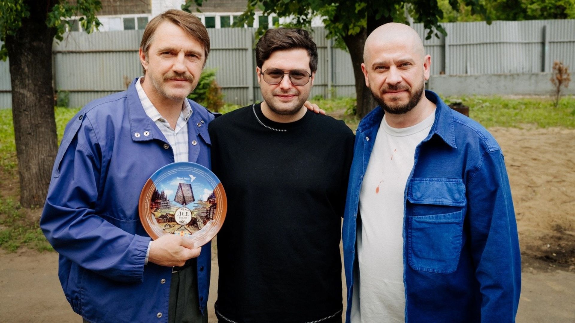 Стас Старовойтов и Владимир Вдовиченков озируют на улице; один держит сувенирную тарелку с логотипом фильма «Батя 2»