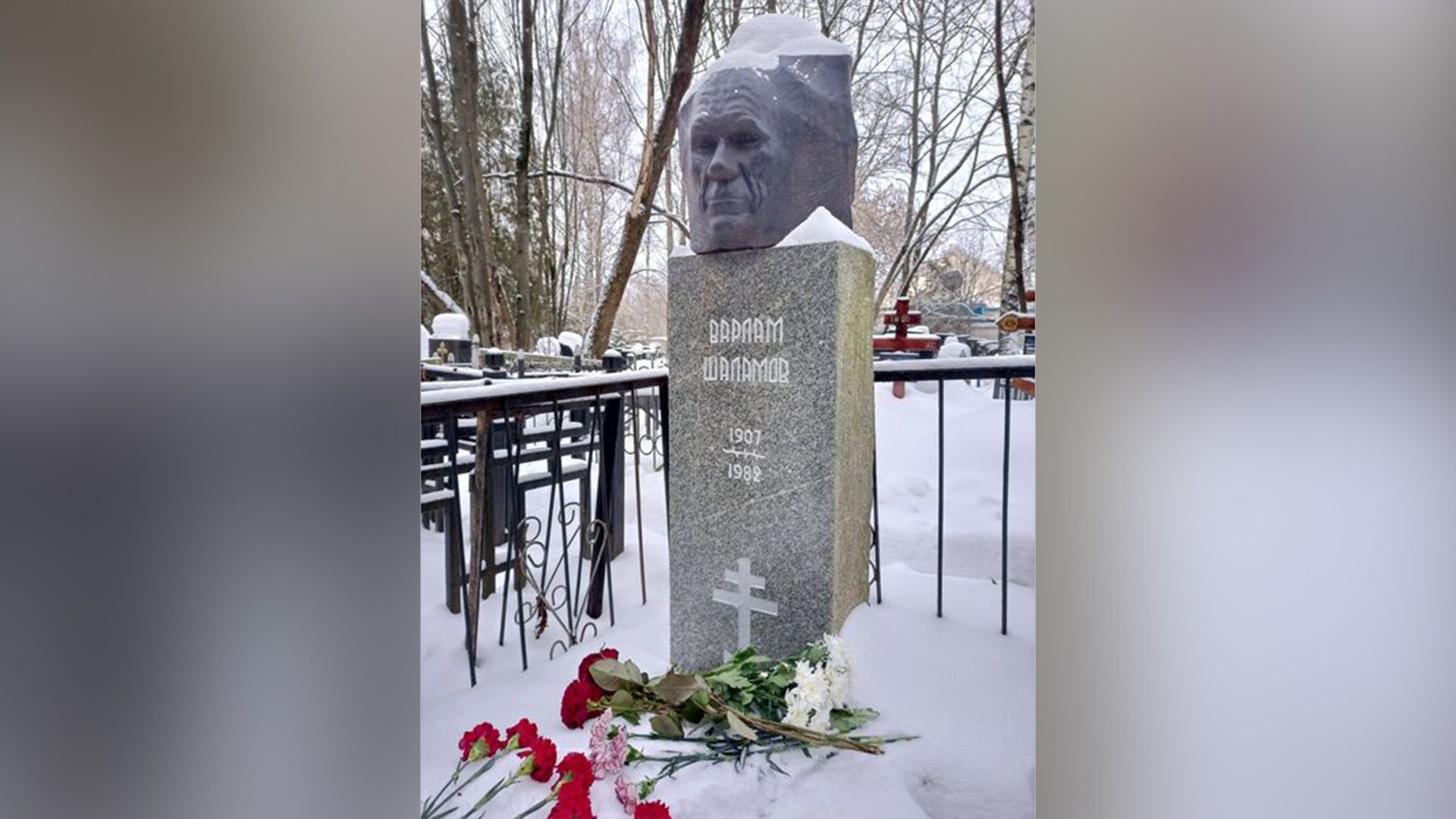 Могила Варлама Шаламова в снегу, на могиле лежат красные гвоздики