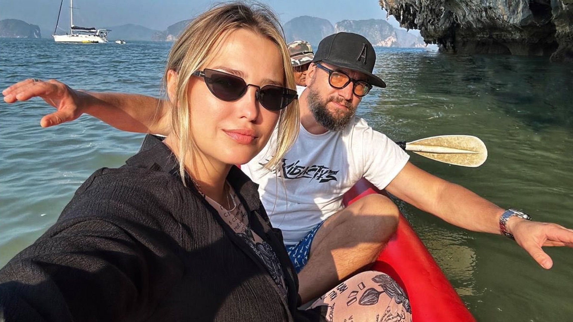 Аглая Шиловская и Александр Устюгов на лодке, на фоне тропический пейзаж