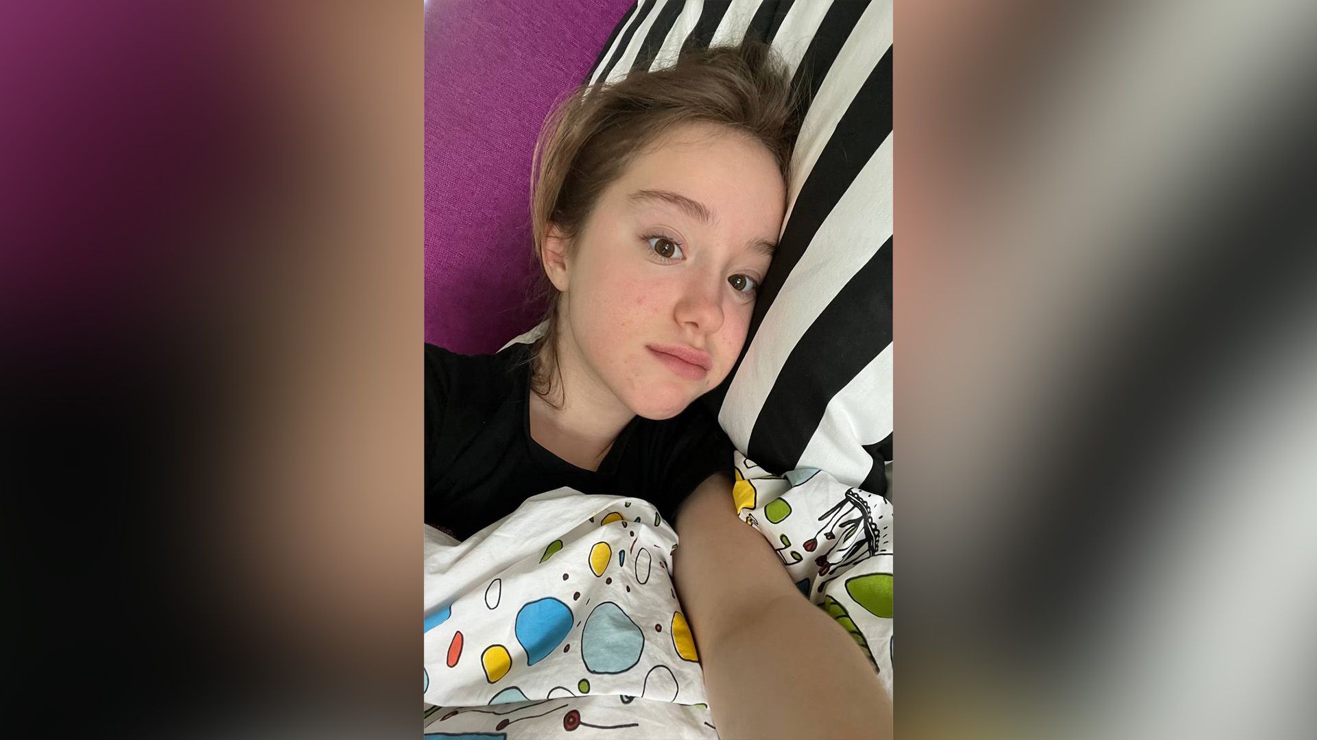 Марьяна Локель в детстве лежит на полосатой подушке