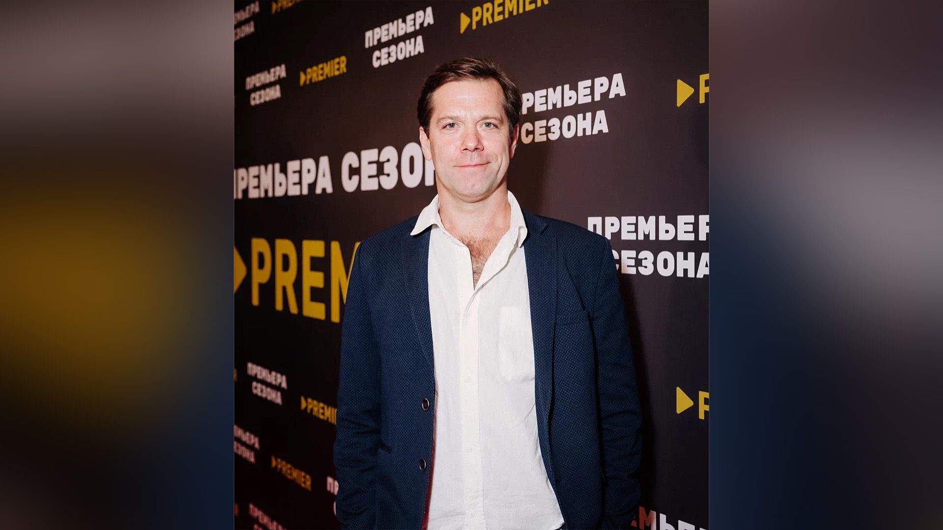 Владимир Селезнев в синем пиджаке и белой рубашке улыбается, глядя в камеру