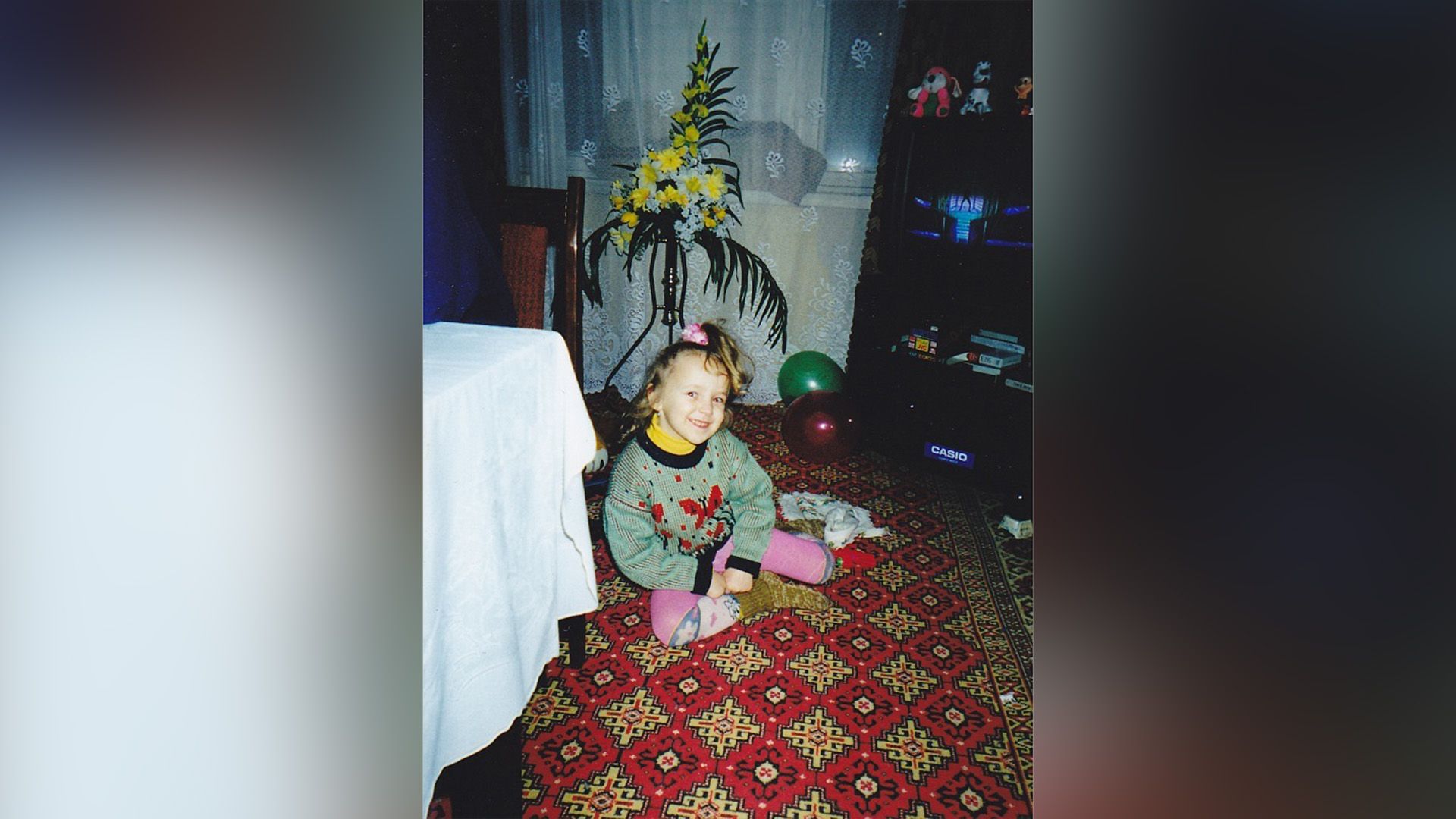 Карина Мурашкина в детстве сидит на полу