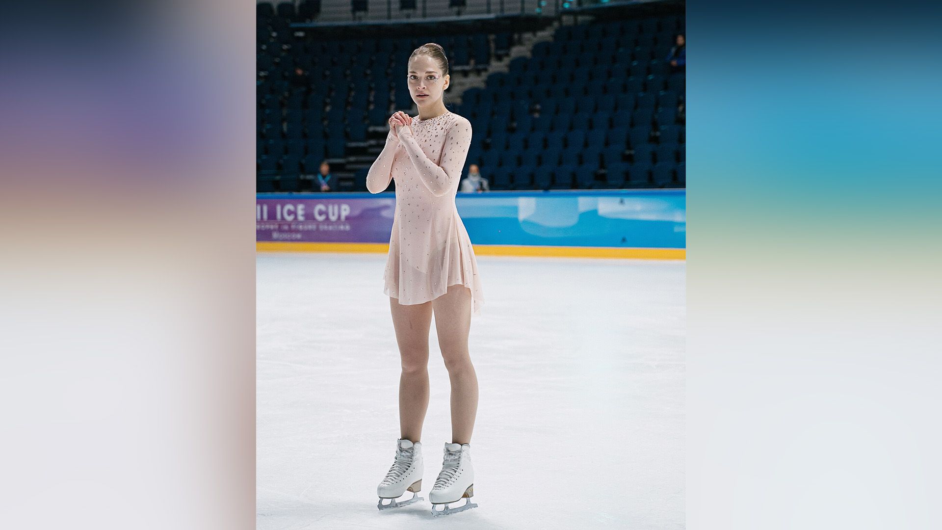 Анна Савранская в костюме фигуристки стоит на ледовой арене