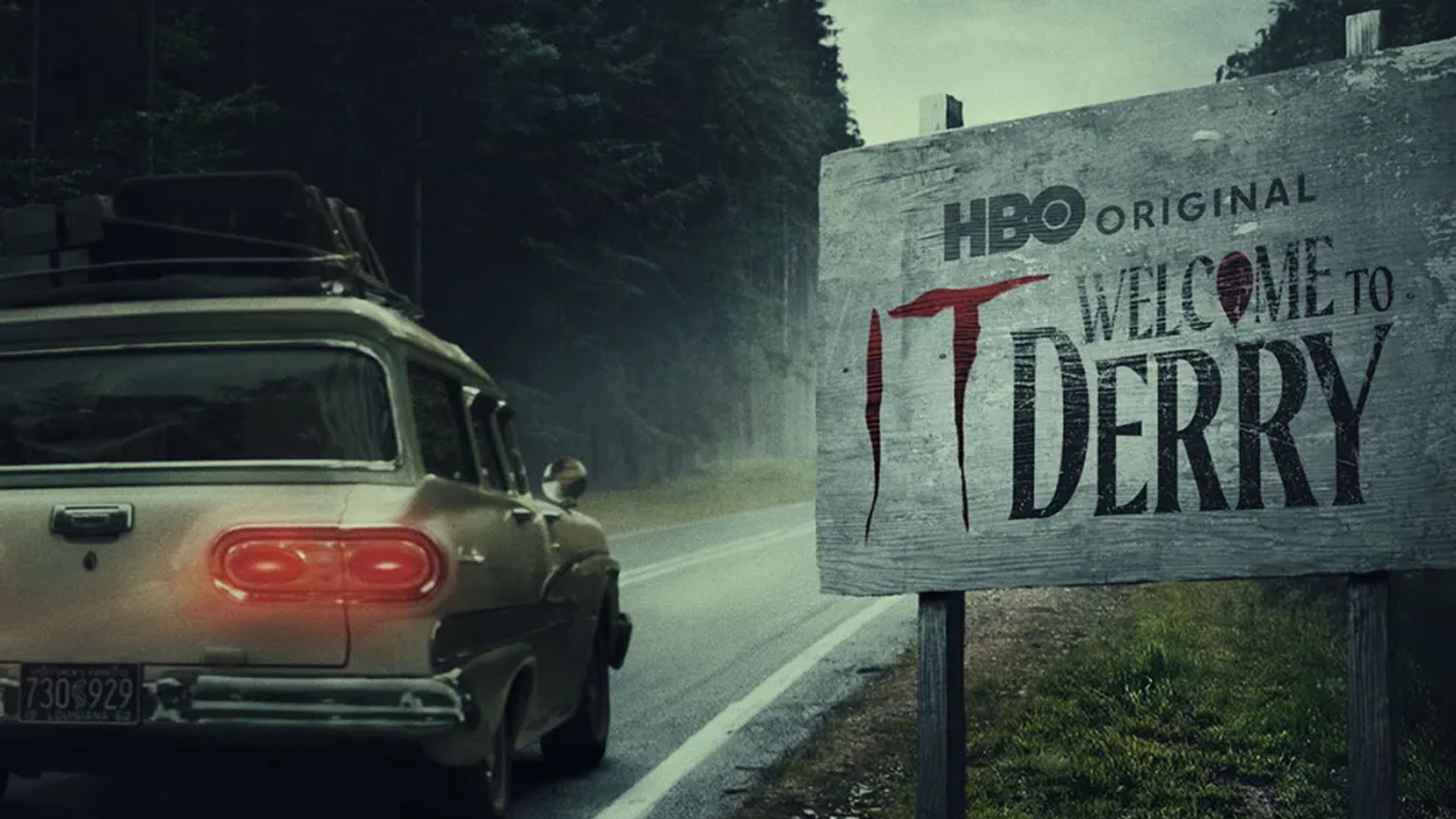Старый автомобиль едет по шоссе мимо дорожного щита с надписью "HBO Original IT: Welcome to Derry"