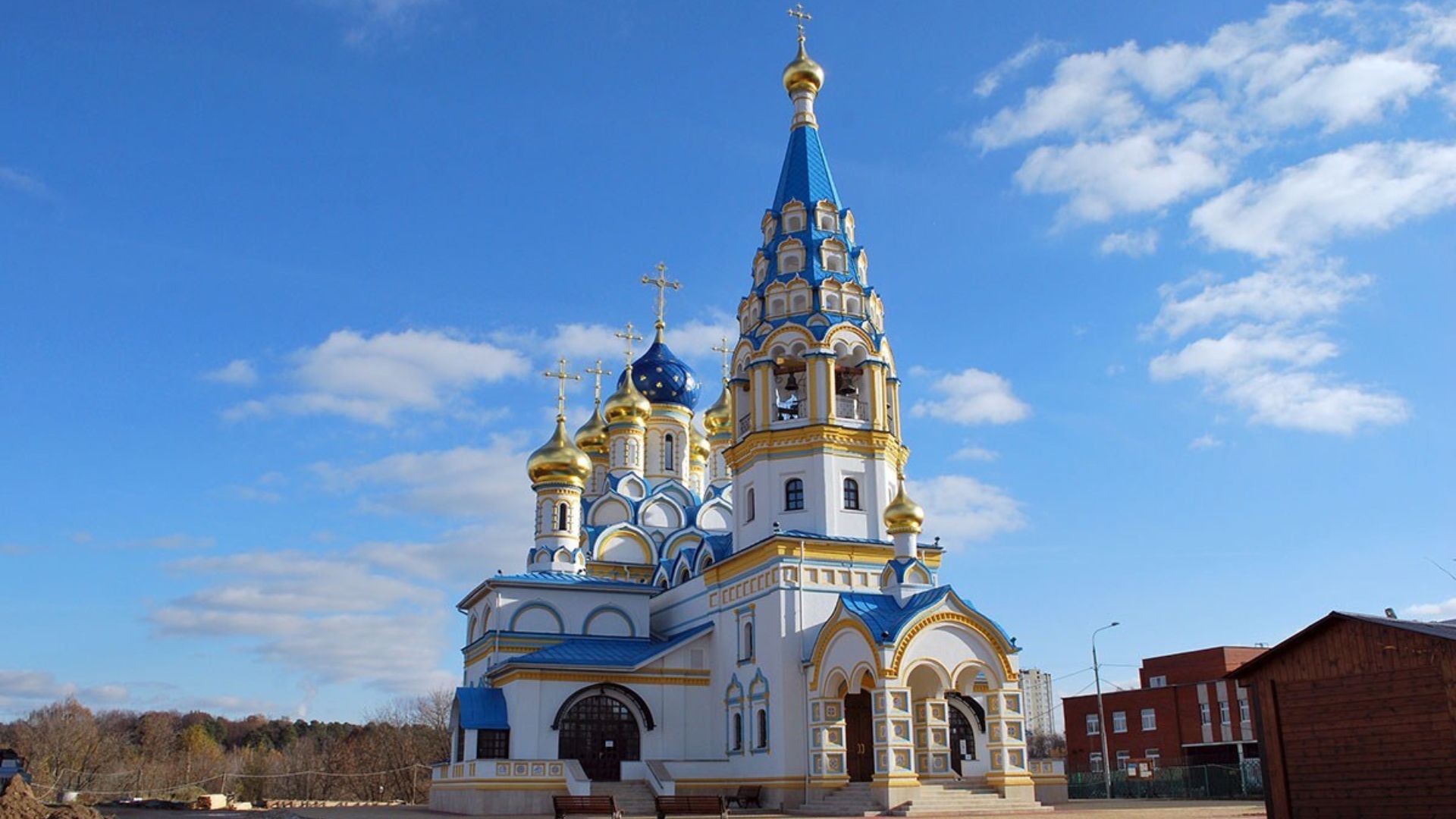 Православный храм с белыми стенами, голубой отделкой и золотыми куполами