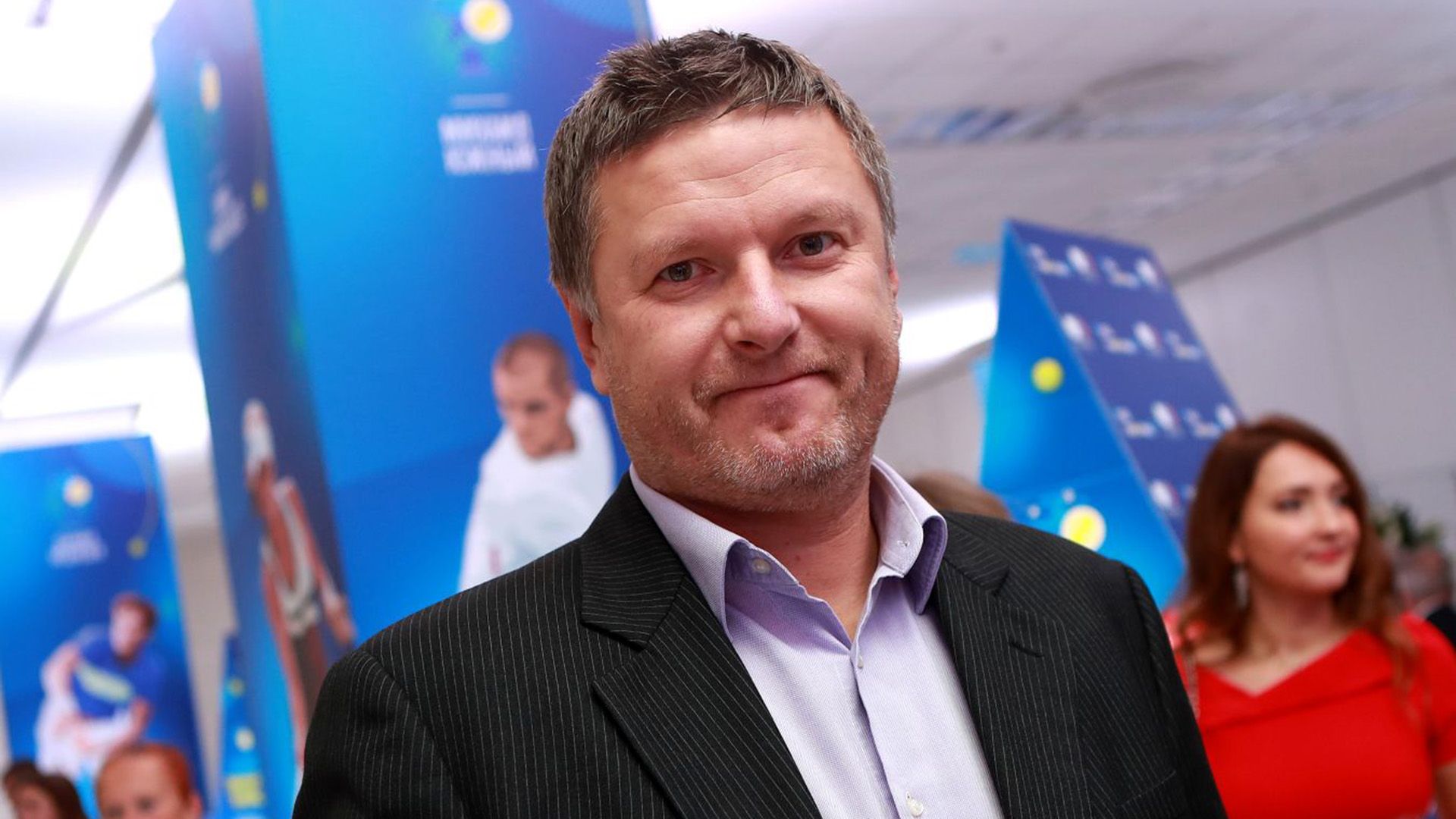 Евгений Кафельников в пиджаке и рубашке смотрит в камеру