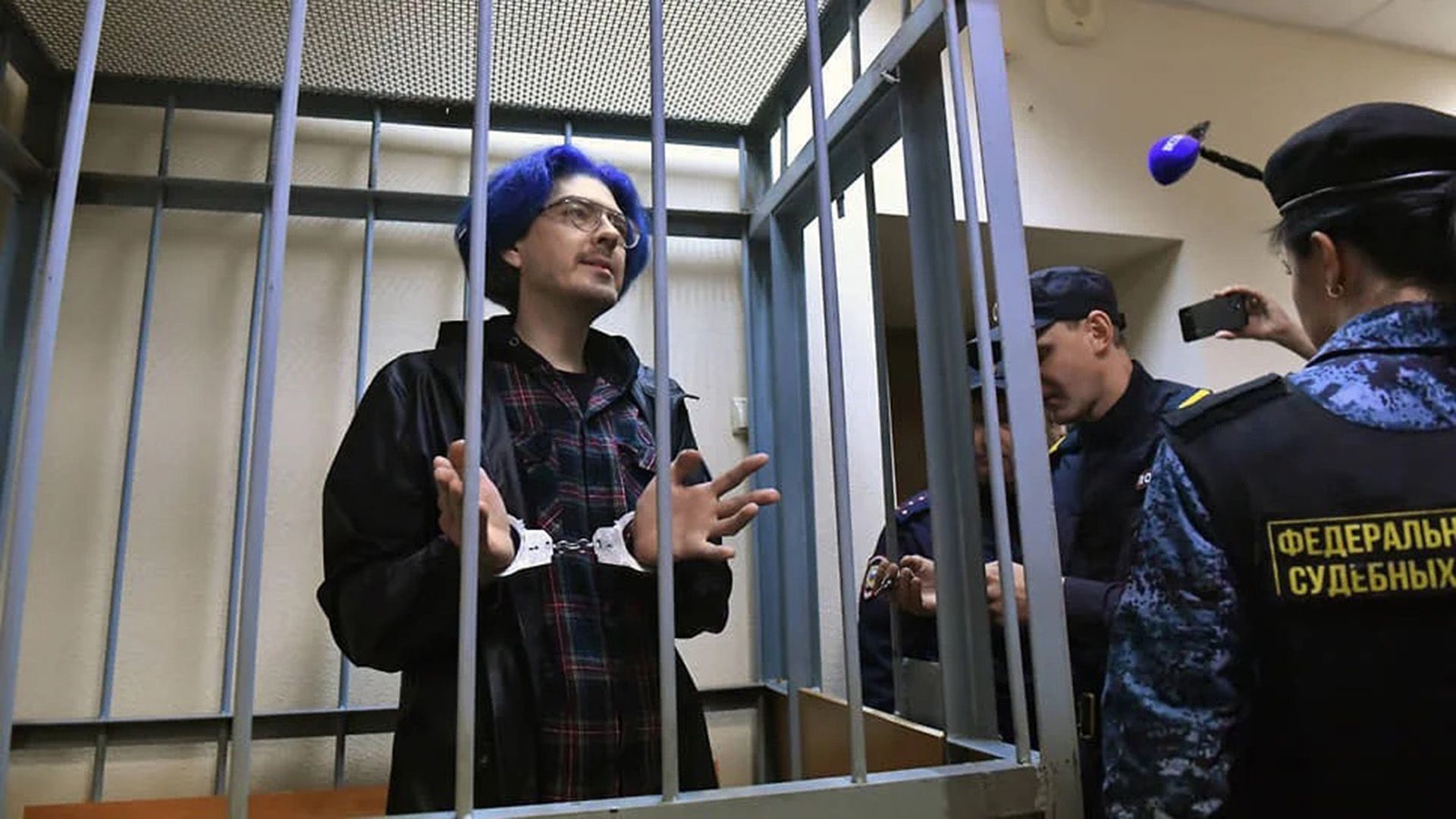 Алексей Поднебесный в наручниках за решёткой в зале суда