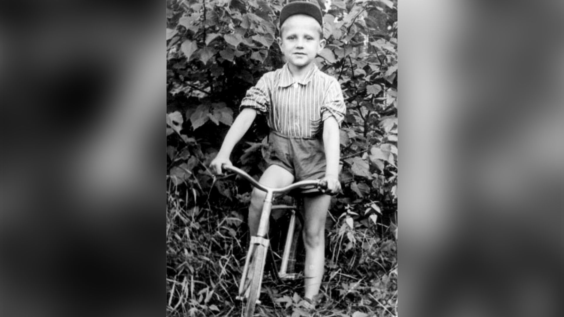 Анатолий Алёшин в детстве сидит на велосипеде