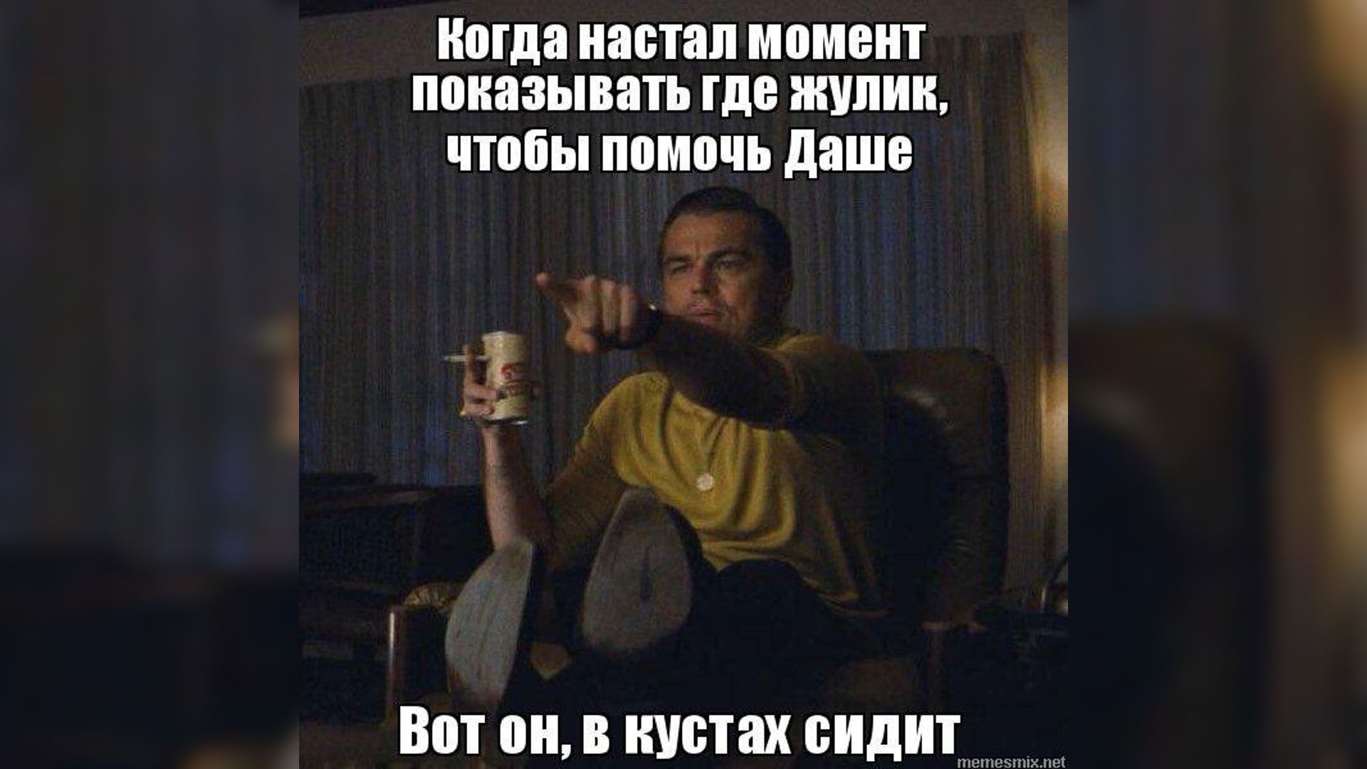 Актер Леонардо Ди Каприо сидит в кресле и показывает пальцем куда-то
