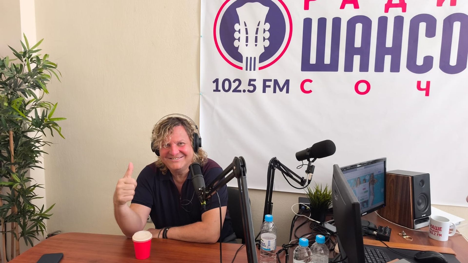 Александр Ягья в радиостудии, на фоне надпись Радио Шансон