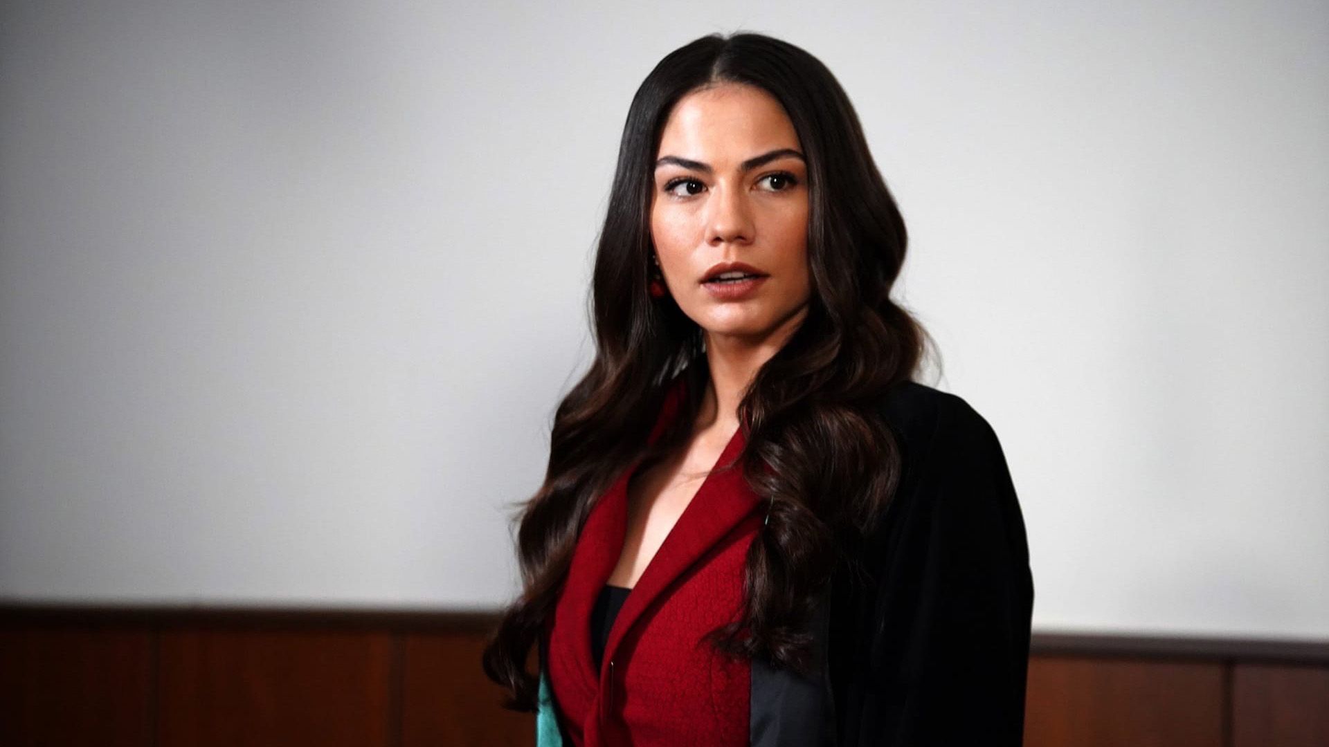 Демет Оздемир в красной блузке и чёрном пиджаке